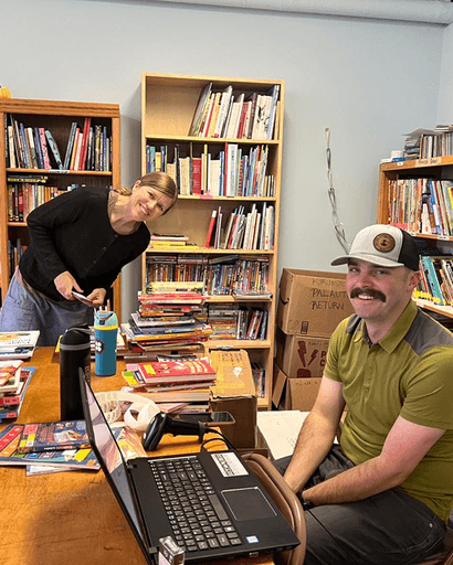 Finnish School librarian and volunteer stocking the library