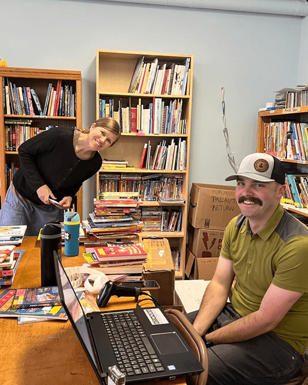 Finnish School librarian and volunteer stocking the library