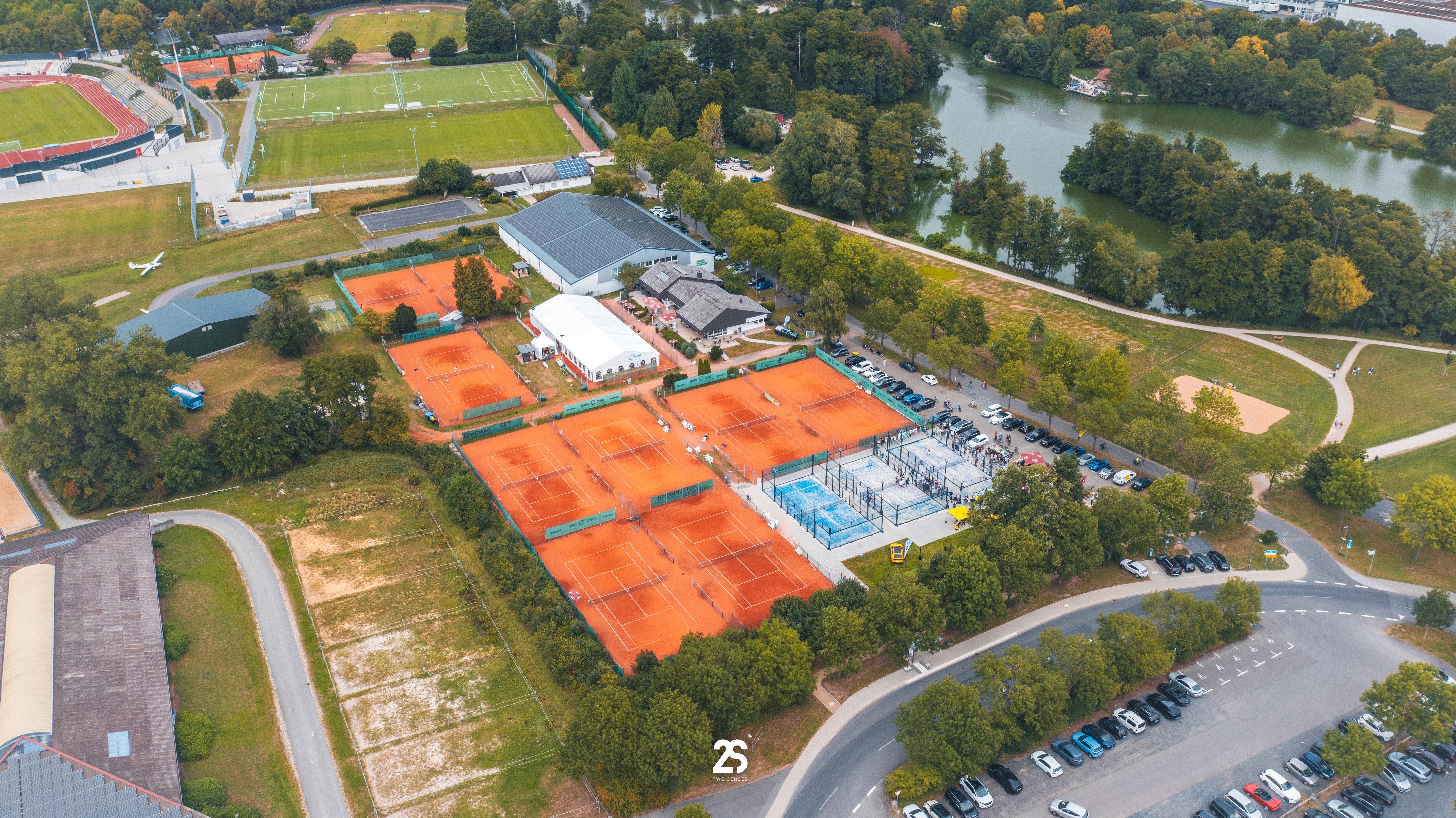 A close-up of a hand wearing multiple decorative rings against a blue background.