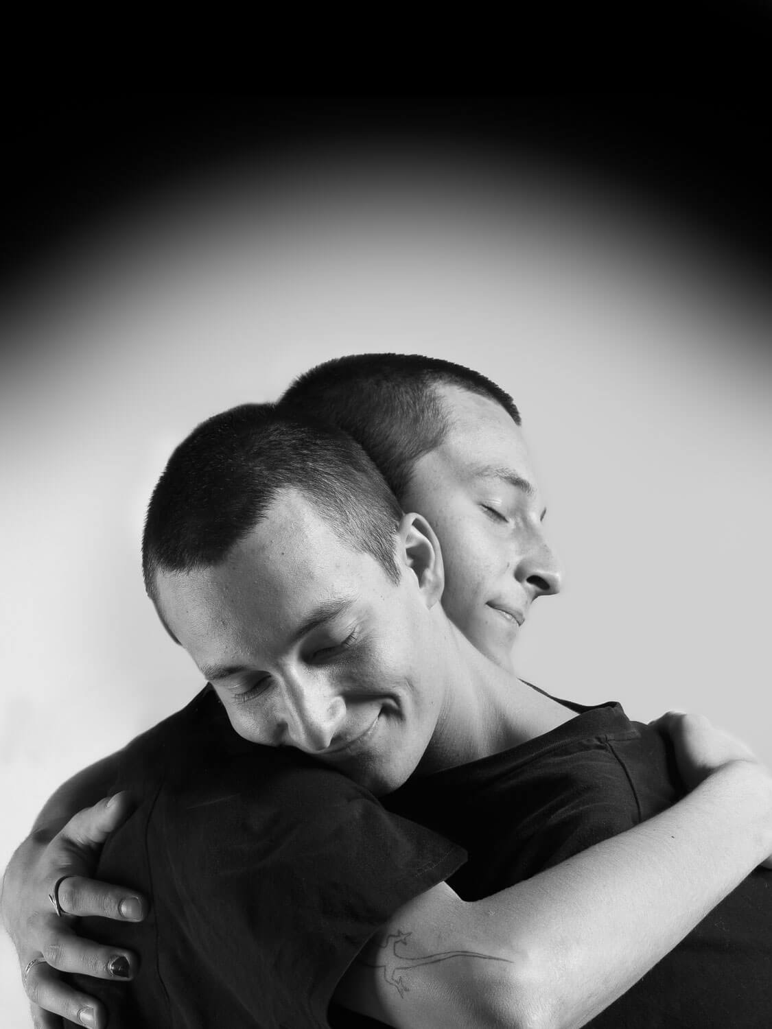 The same person hugs themselves in black and white