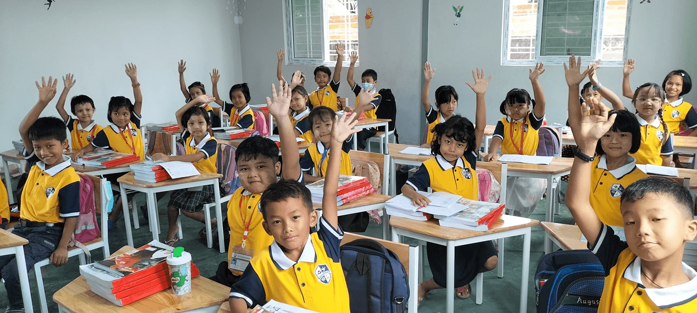 Elpis International School students raising their hands in a classroom in Yangon, Myanmar