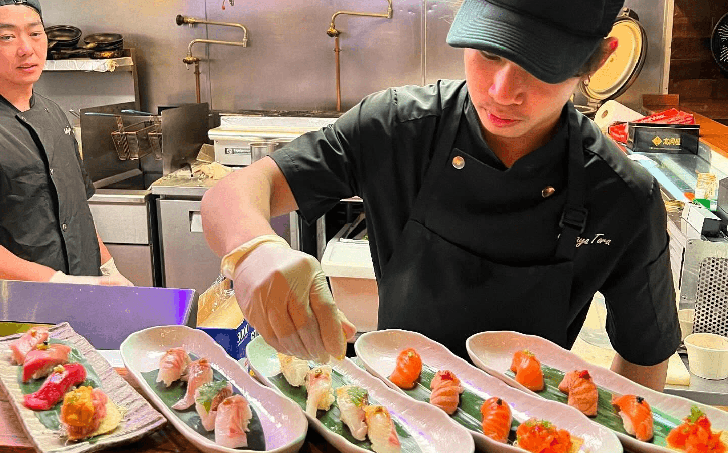 A behind-the-scenes look at Izakaya Tora’s chef crafting fresh sushi and yakitori, showcasing the artistry and precision of Japanese cuisine.