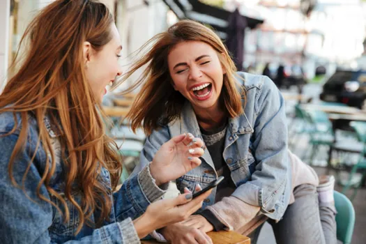 women laughing wearing jean jackets