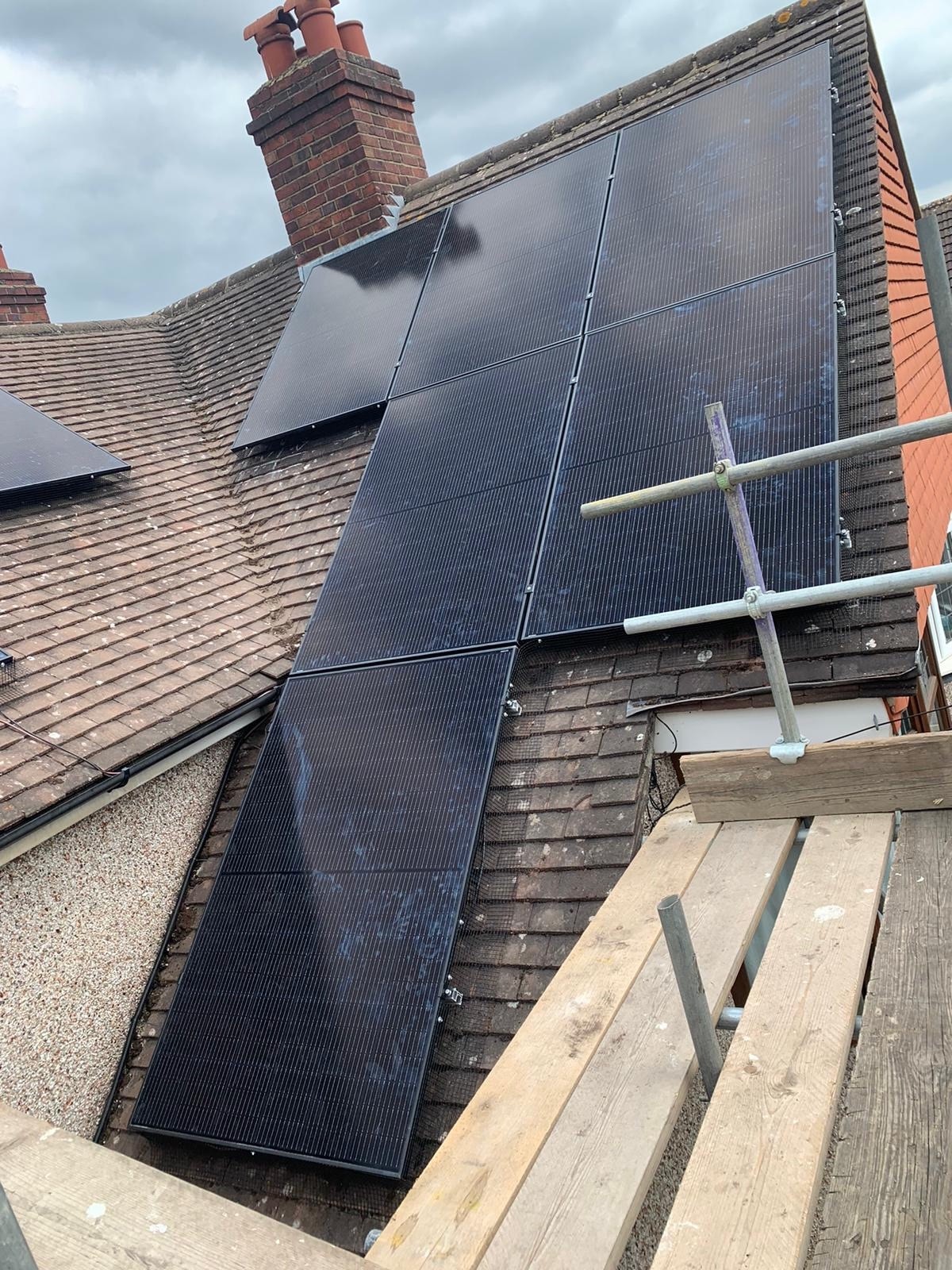 Solar panels fitted around the chimney on the pitched roof at Nina's home