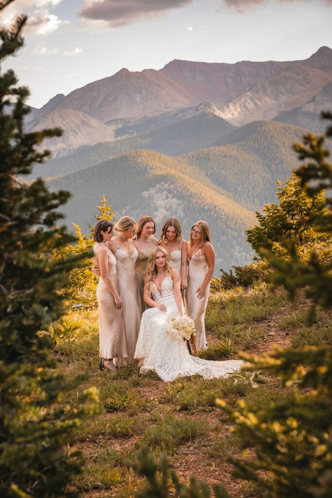 Bride posing with attendants in front of mountain views