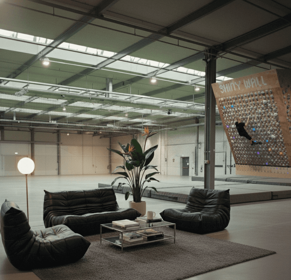 Urbaner Indoor-Boulderraum mit Lounge-Bereich und digital gesteuerter Shiny Wall Systemwand – Bouldern, Community und Functional Fitness in München.