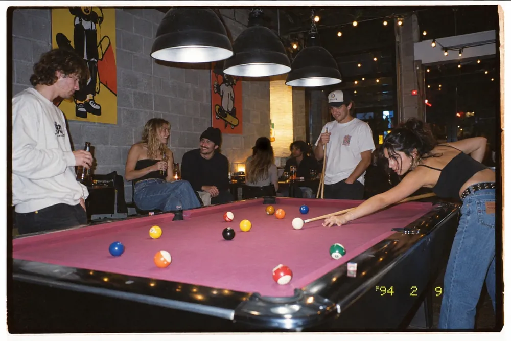 Friends playing pool late at night