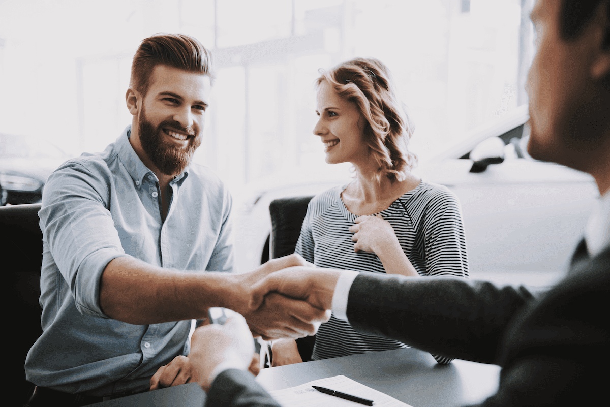 SPIN selling: Smiling woman looking at two men shaking hands