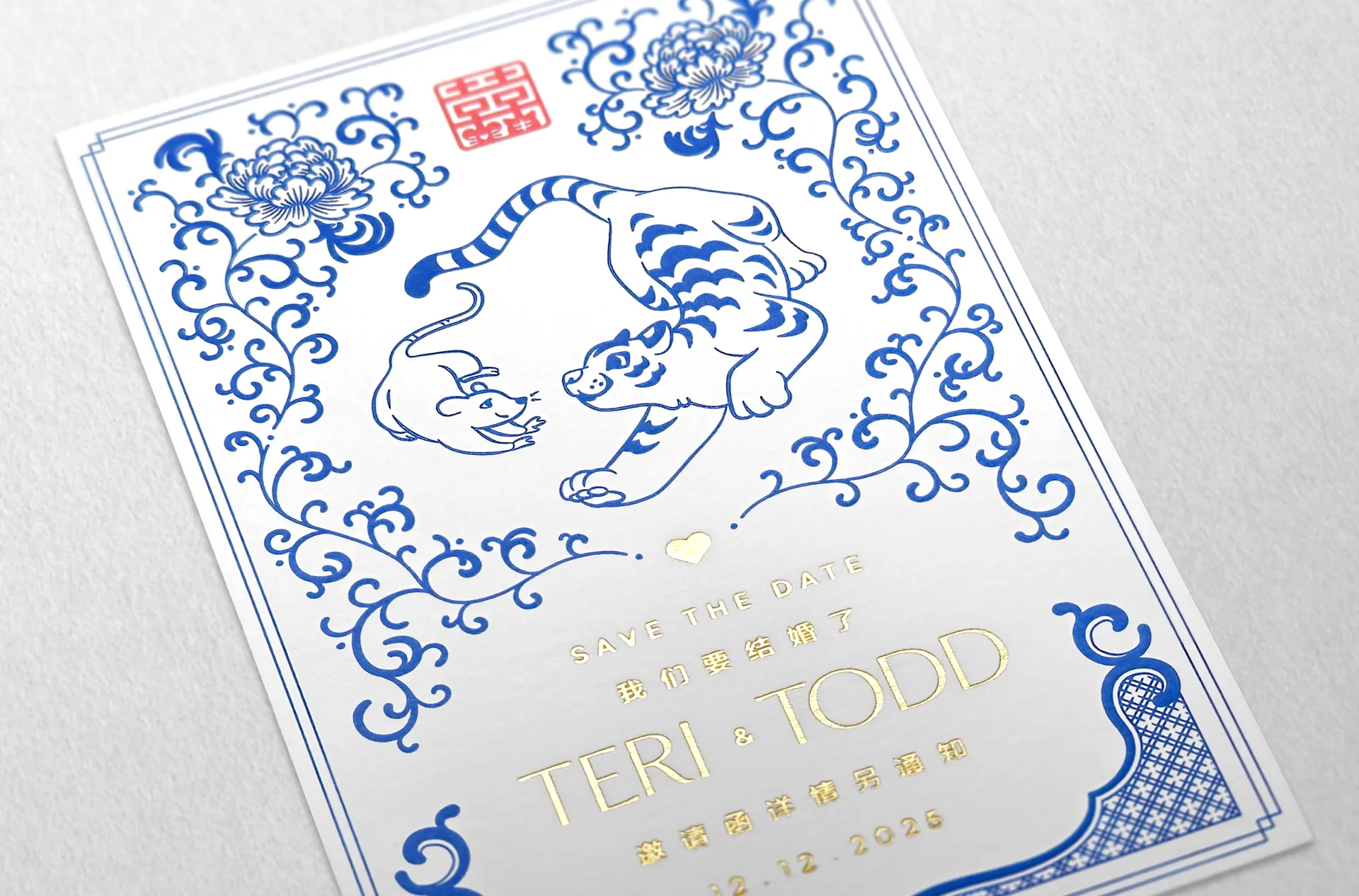 Save the date card for Teri & Todd's Wedding with a blue-porcelain themed illustration of a rat and tiger in peony vines and debossed text in gold leaf