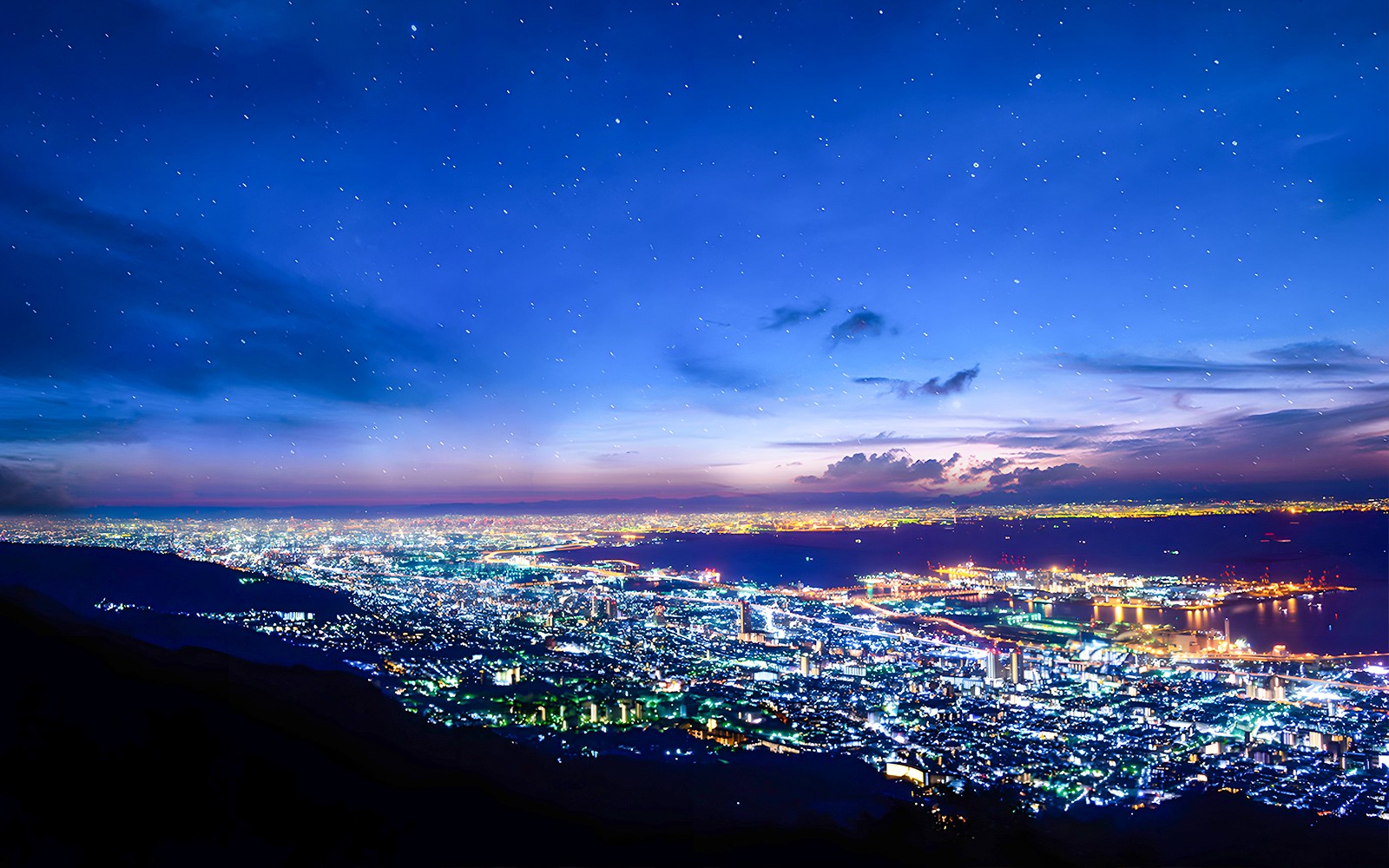 Night view of Kobe cityscape from Mt. Rokko, with city lights and starry sky.