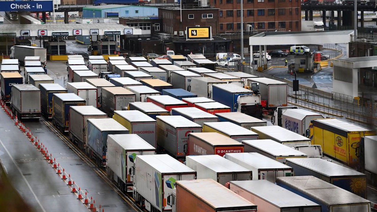 Trucks waiting at a border crossing, representing the challenges and delays in post-Brexit border compliance.