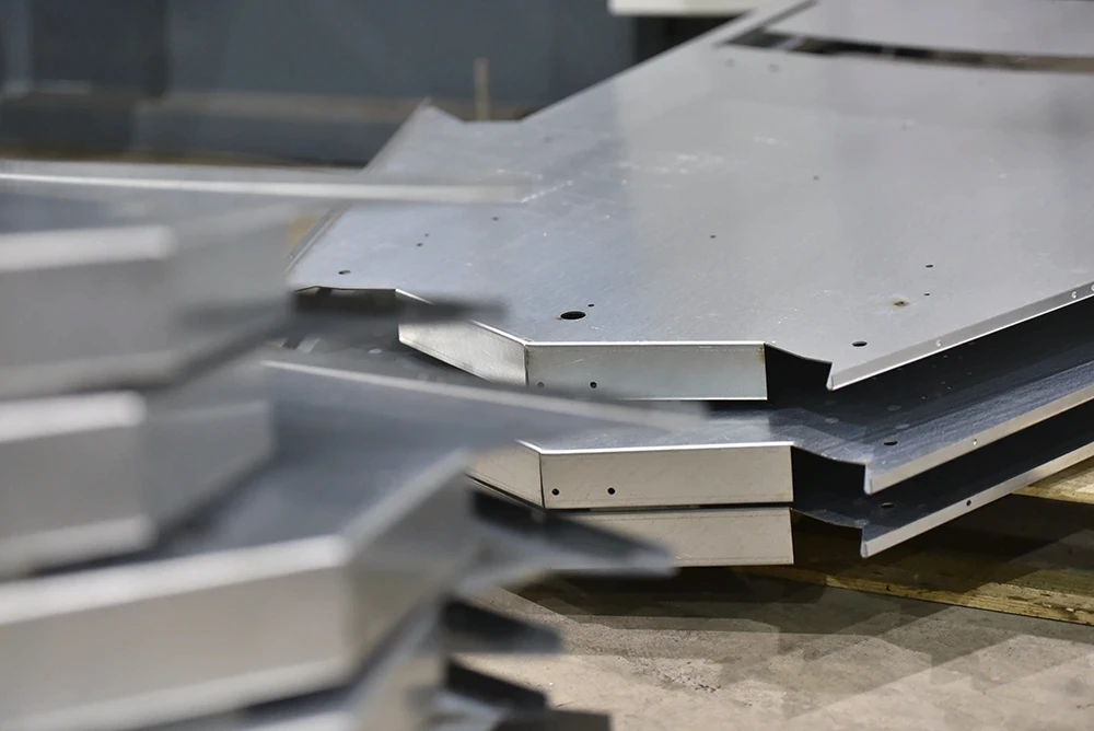 Stacked folded metal components ready for assembly at CASC’s fabrication facility.