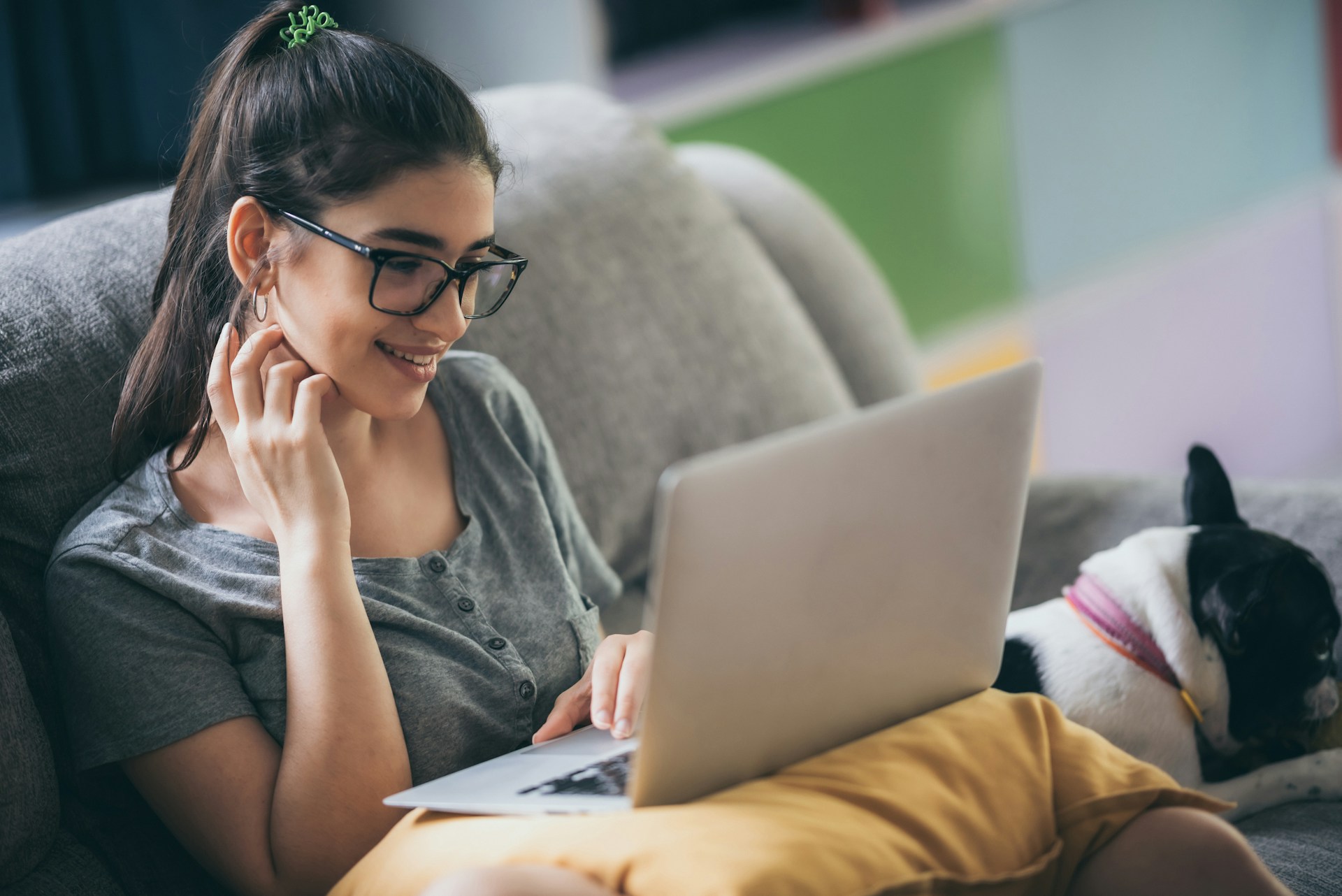 A woman using a laptop on a couch
