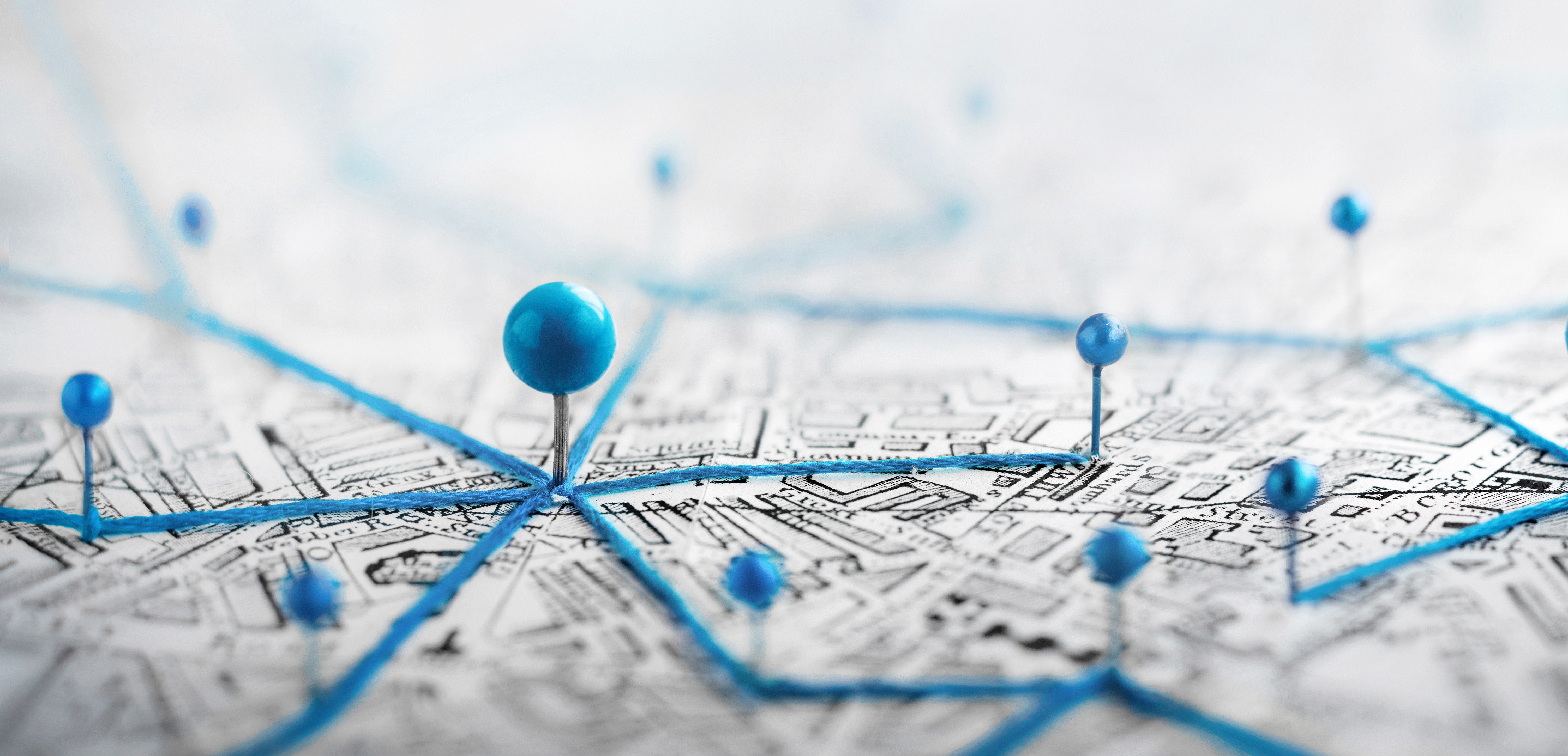 A map with pins in different locations and strings between each of the pins, connecting them.