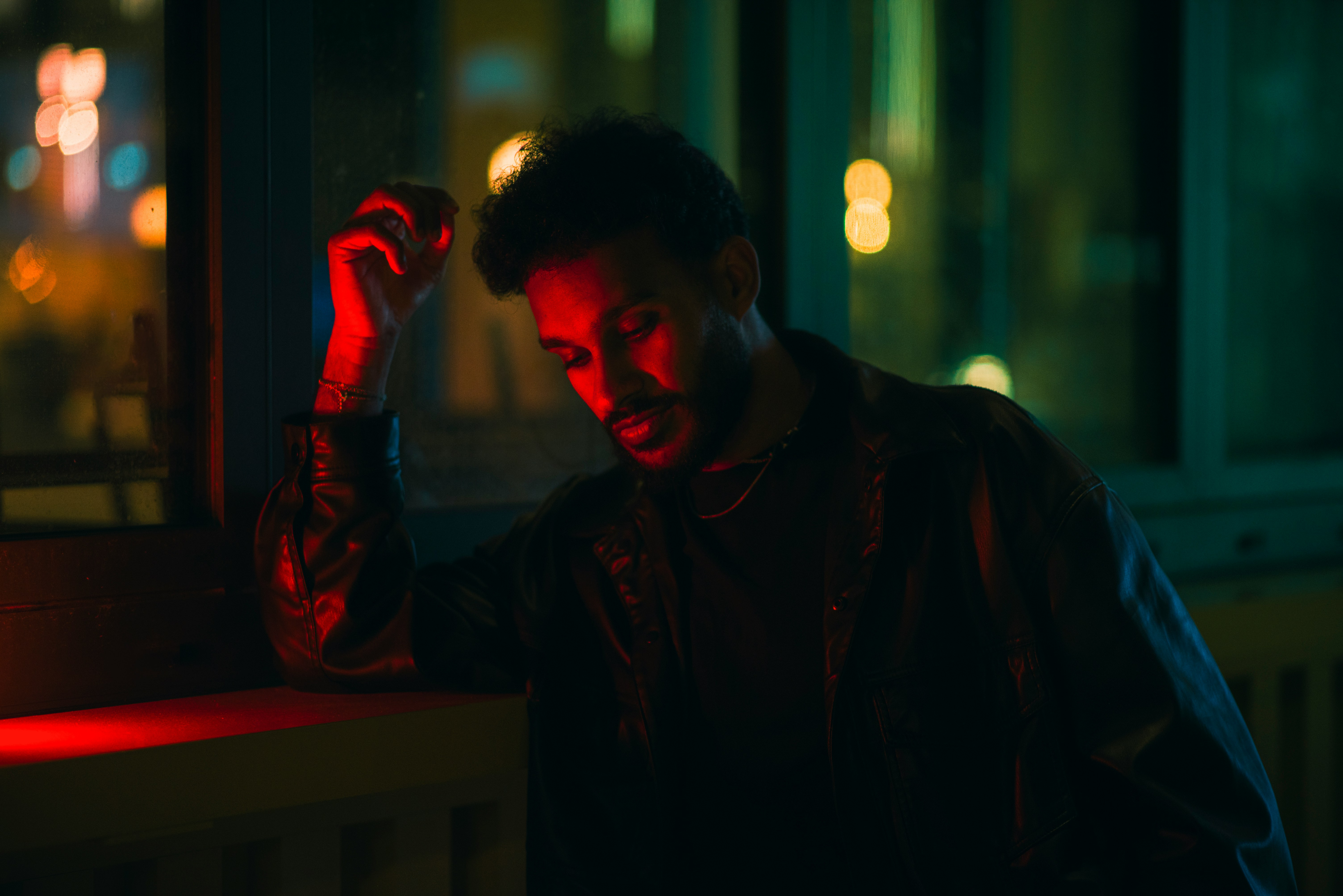 Man leaning on a railing with red light