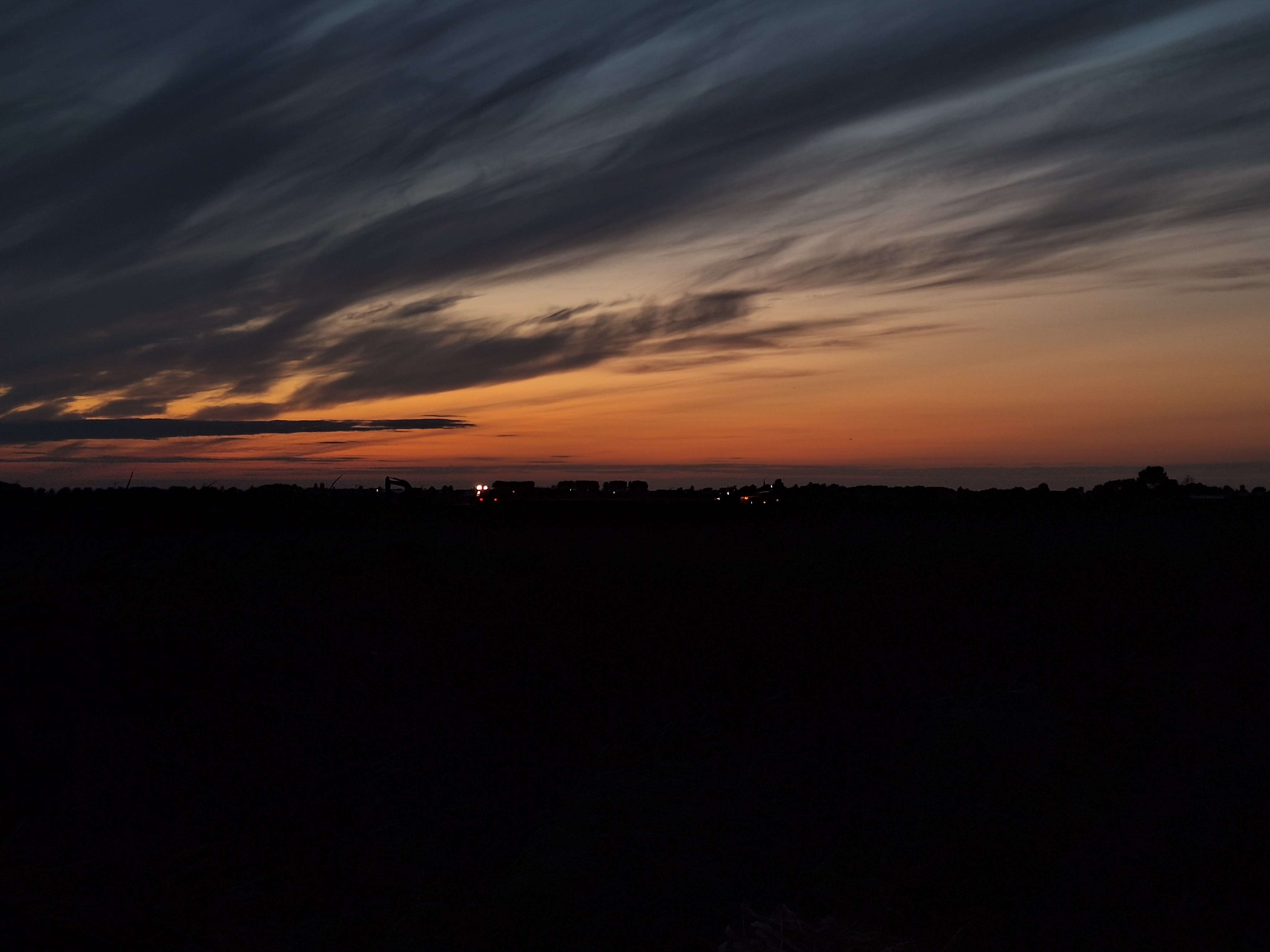 A close-up of a hand wearing multiple decorative rings against a blue background.
