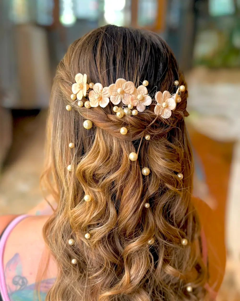 Tocado de flores de porcelana en frío y perlas colgantes en peinado semirrecogido