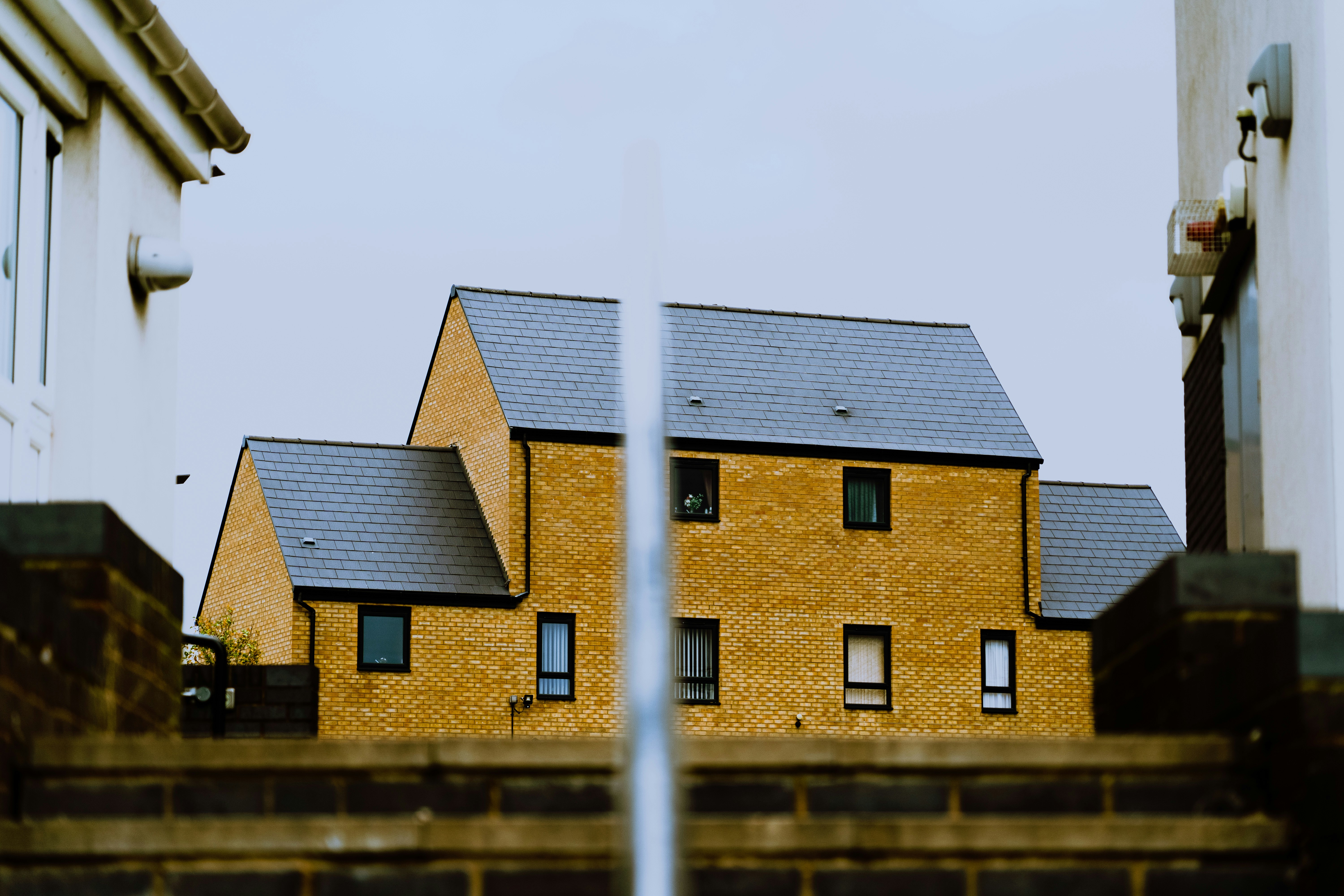 a yellow brick house with a black roof