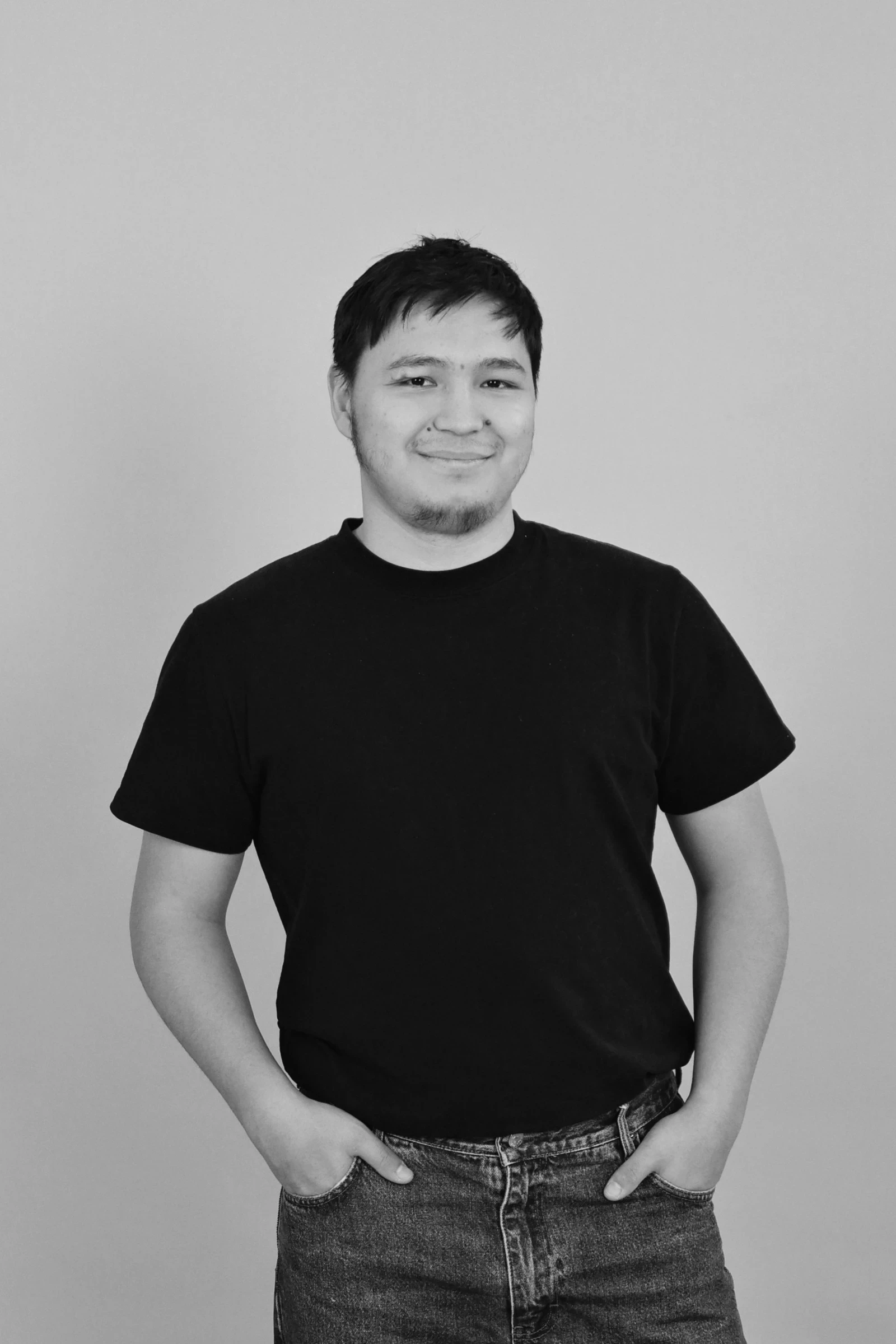 A woman seated at a desk in a minimalist workspace, reviewing architectural models. Large windows offer a view of a serene wooded area.