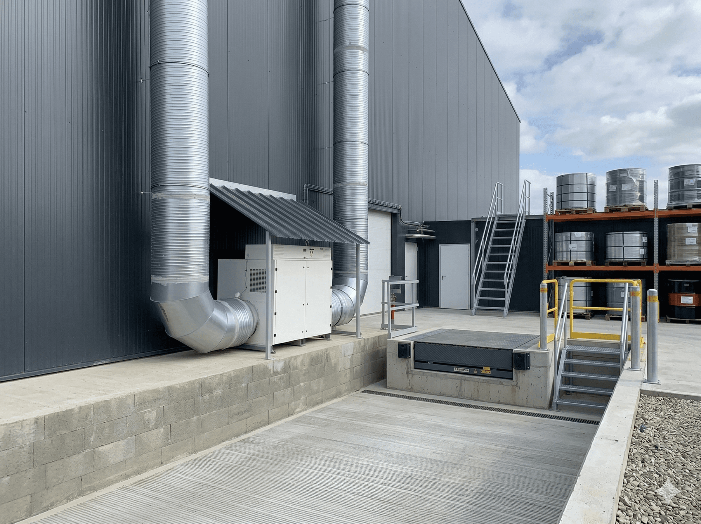 Façade d'un bâtiment industriel avec système de déshumidifcation d'air, unité technique et quai de chargement extérieur.