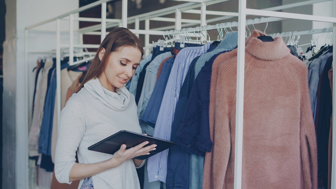 Woman uses a tablet in a clothing store.