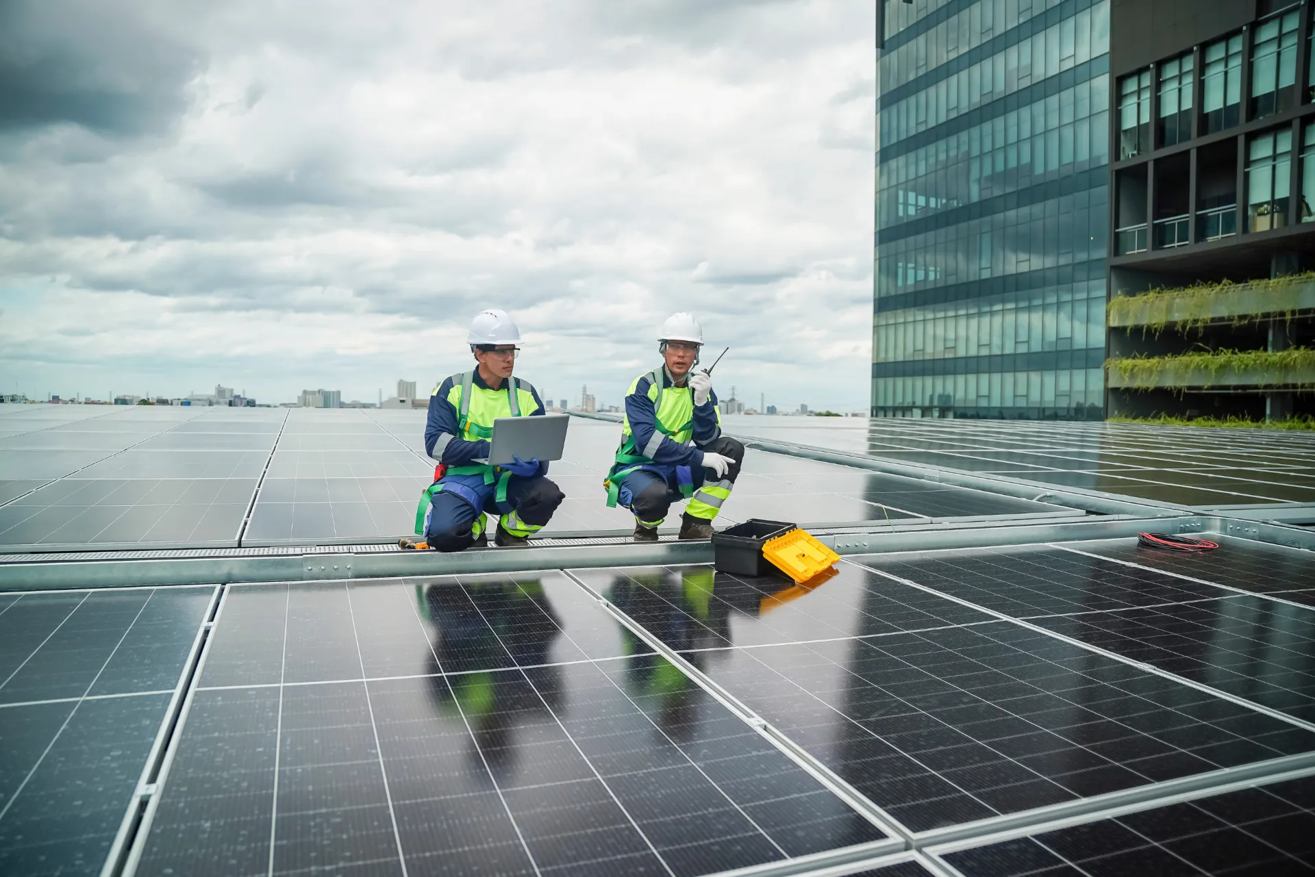 Zwei Personen auf dem Dach auf welchem eine Photovoltaikanlage befestigt ist.