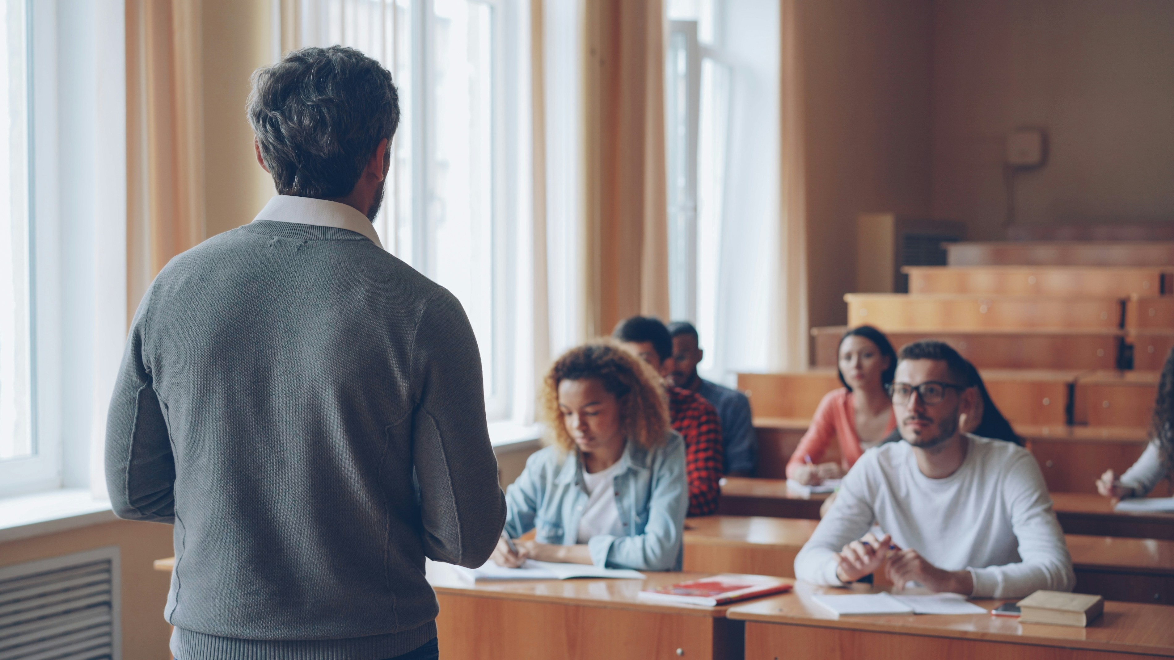 Professor teaching students in a lecture hall.