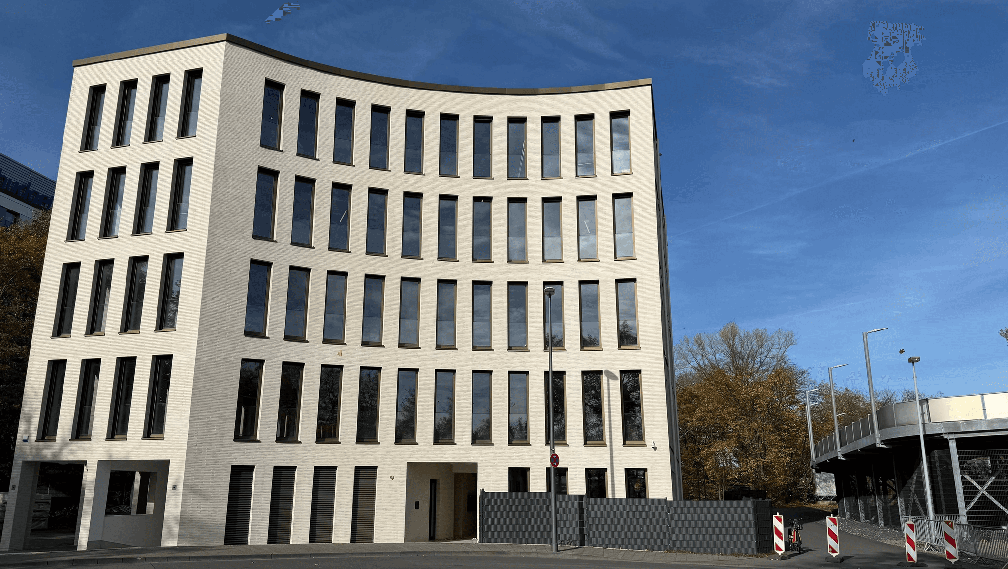 Das Bürogebäude DEUTZ ONE in Köln-Deutz, Sitz der AS Projekte GmbH – modernes Verwaltungsgebäude mit heller Fassade und großflächigen Fenstern unter blauem Himmel.