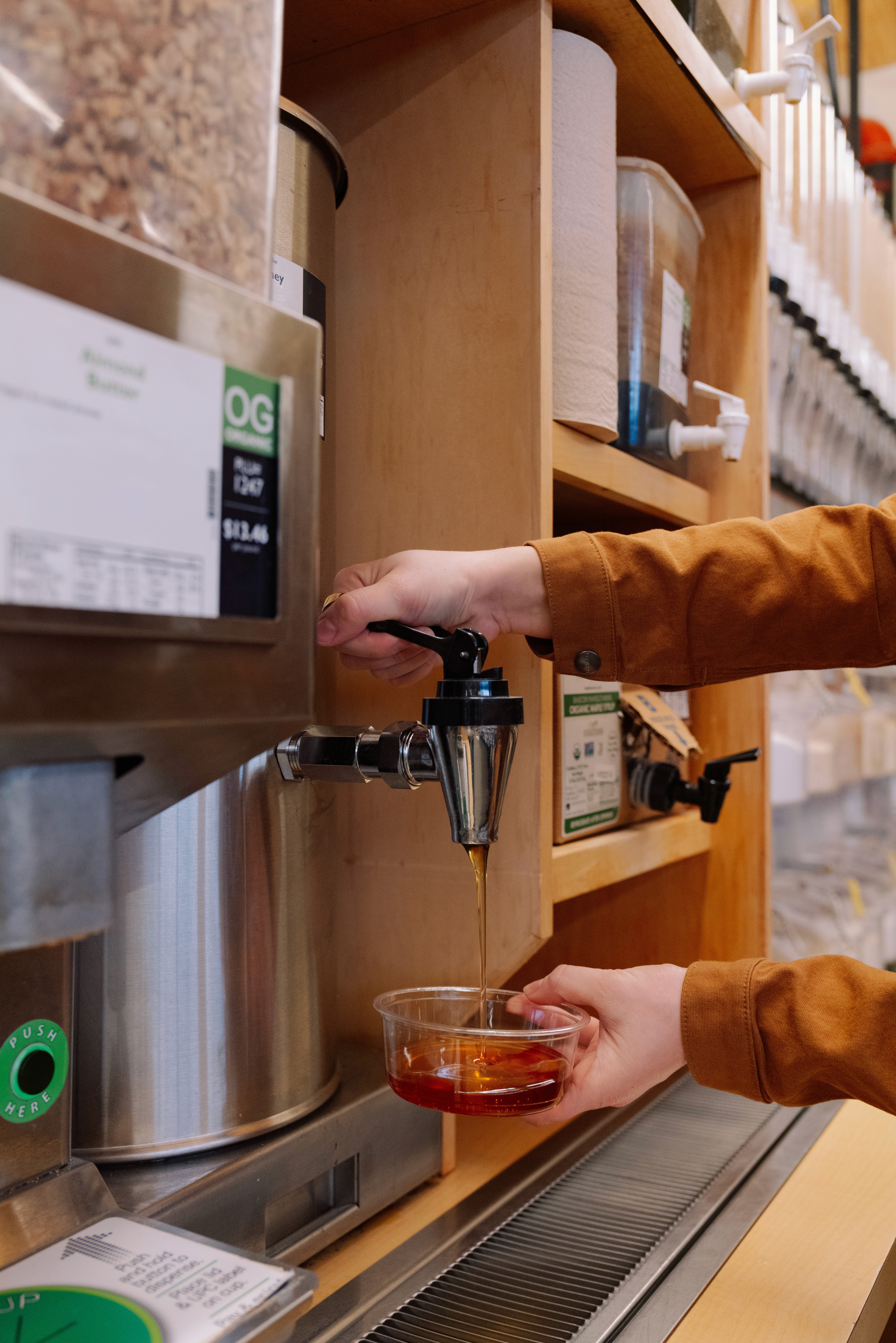 A man and woman browse shelves filled with items in a store, looking at selections and enjoying each other's company.