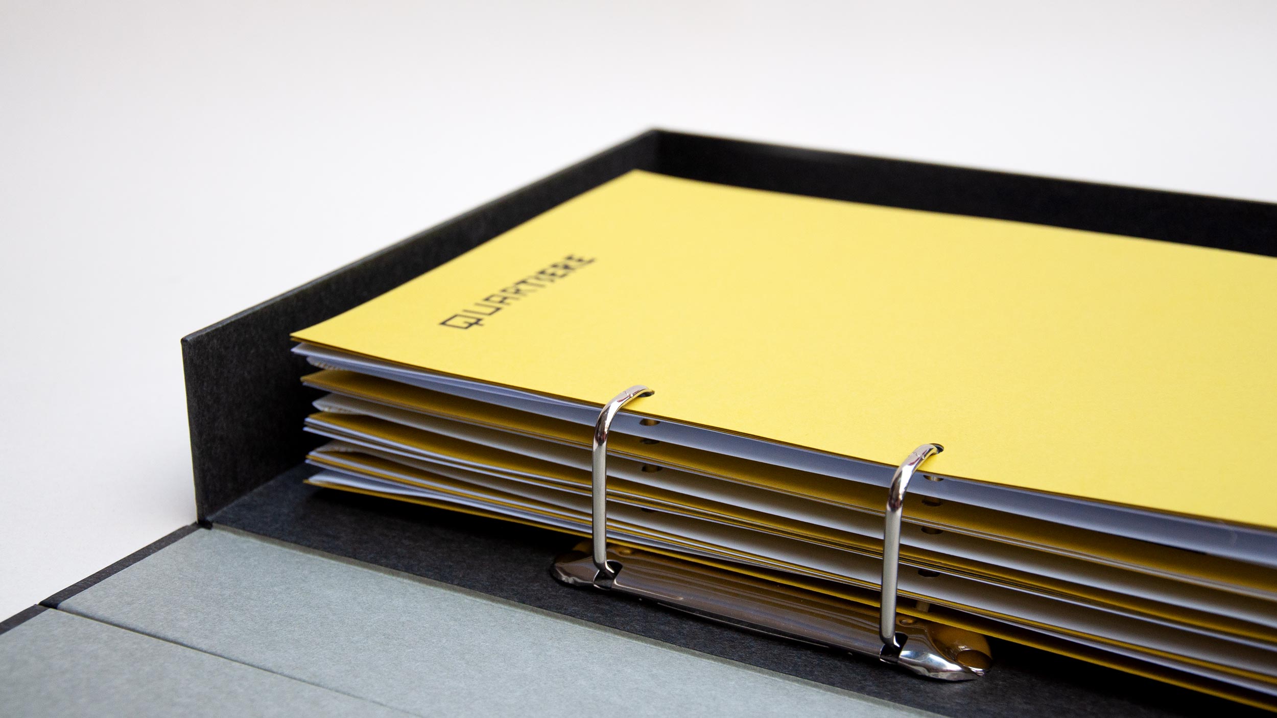 Der Ordner wurde in Zusammenarbeit mit einer Buchbinderin entwickelt und konfektioniert. Materialität, Aufbau und Mechanik wurden gezielt auf das Konzept abgestimmt, sodass Funktion, Haptik und Gestaltung eine Einheit bilden und den Charakter eines architektonischen Arbeitsmittels präzise übersetzen.