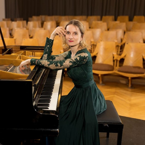Pianist sitting on stage at the piano