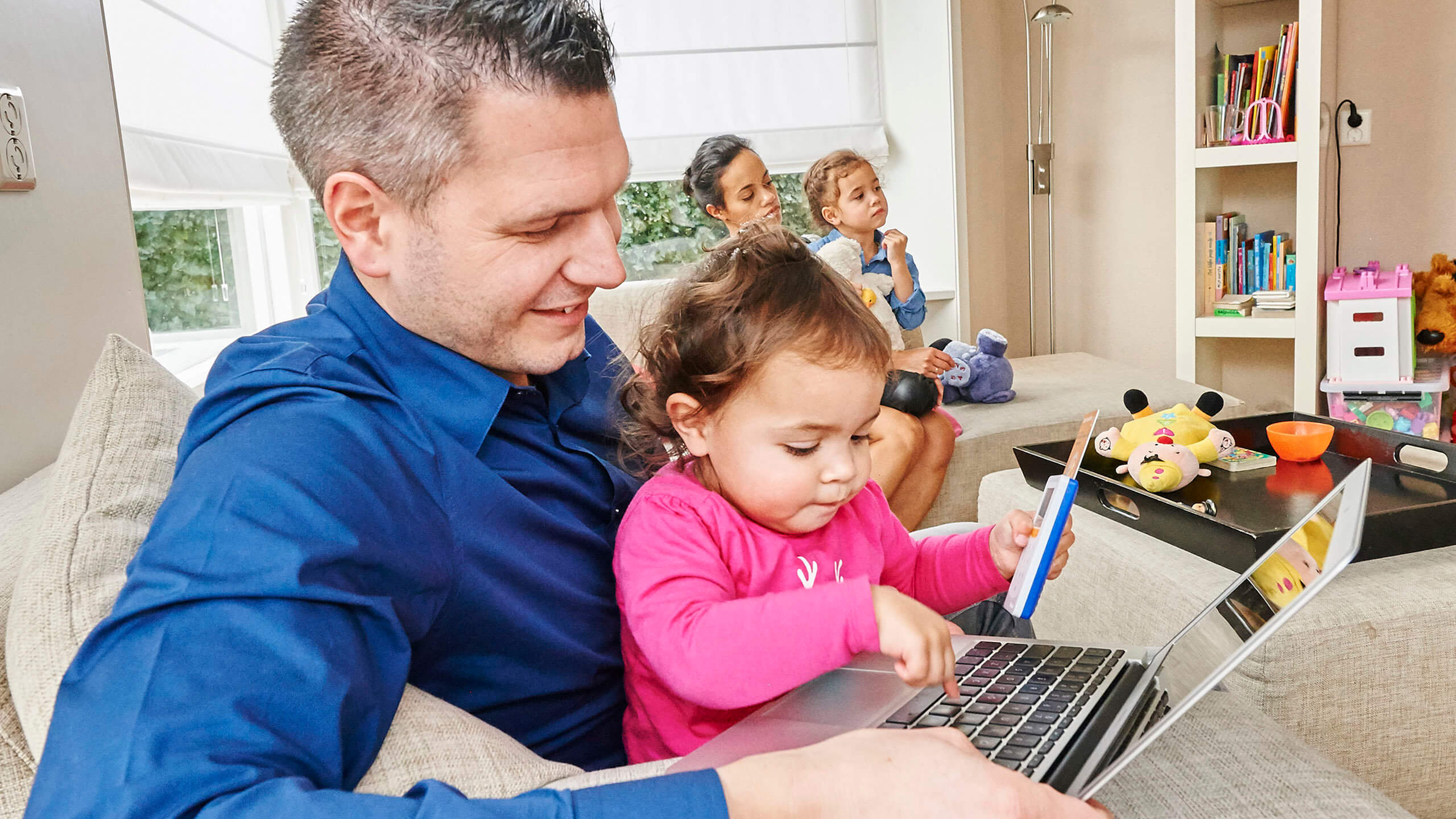 Daddy and daughter telebanking at a laptop