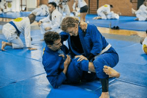 Group huddle of adult students wearing blue and white gis