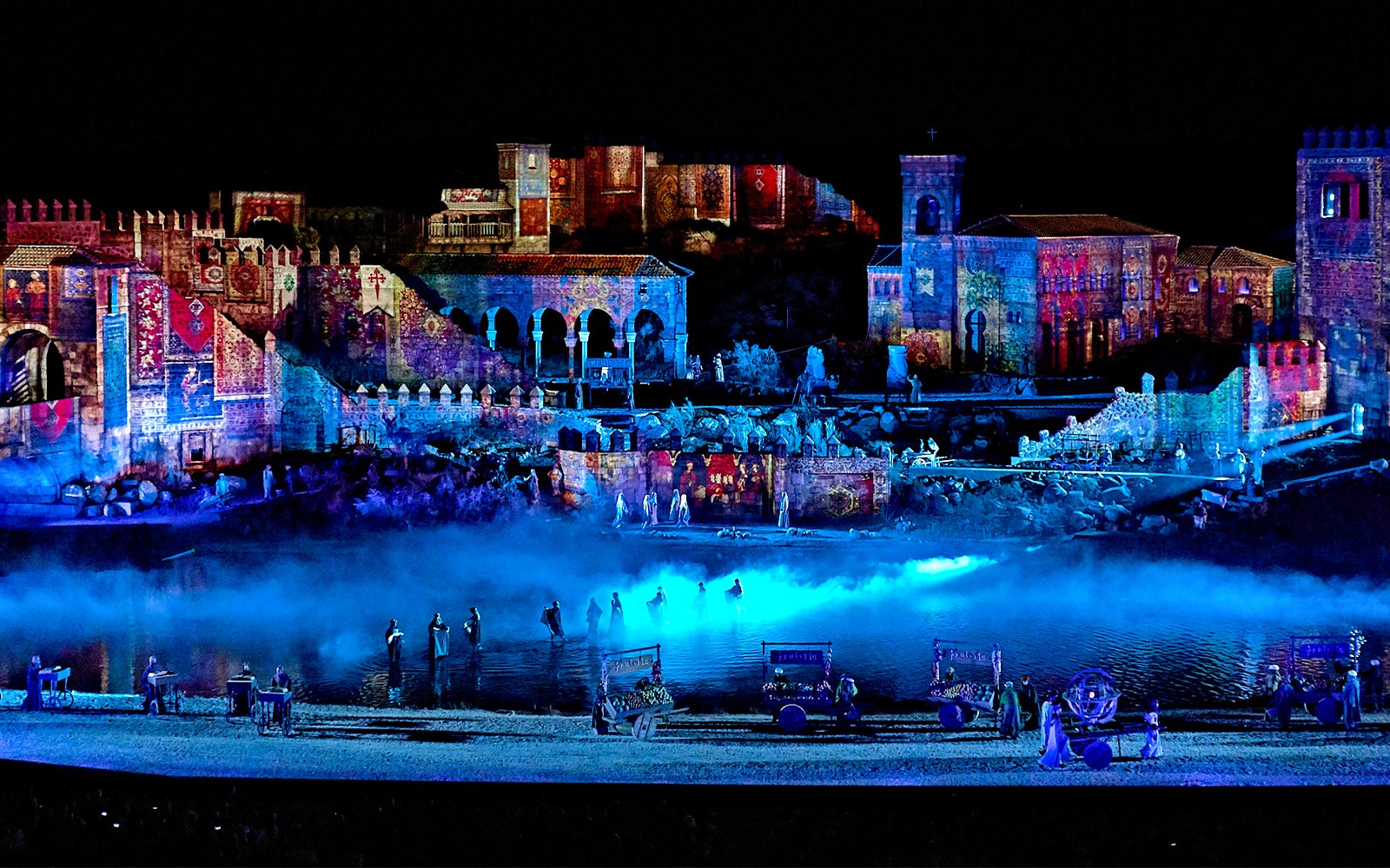 Espectáculo nocturno en Toledo con artistas en trajes históricos en el escenario.