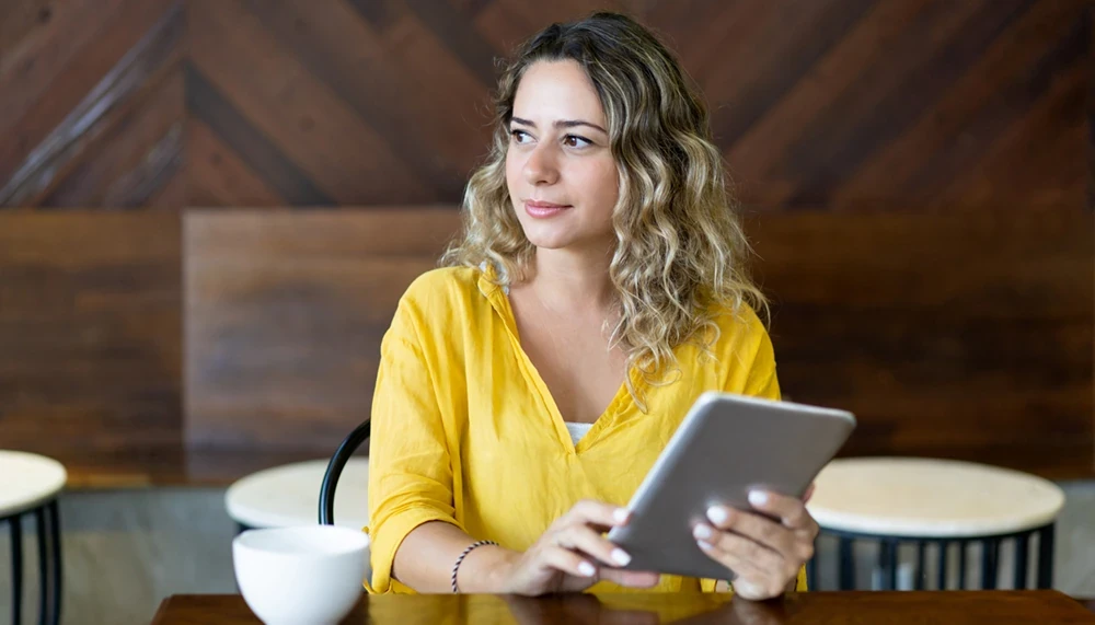 A woman is reading something on a tablet