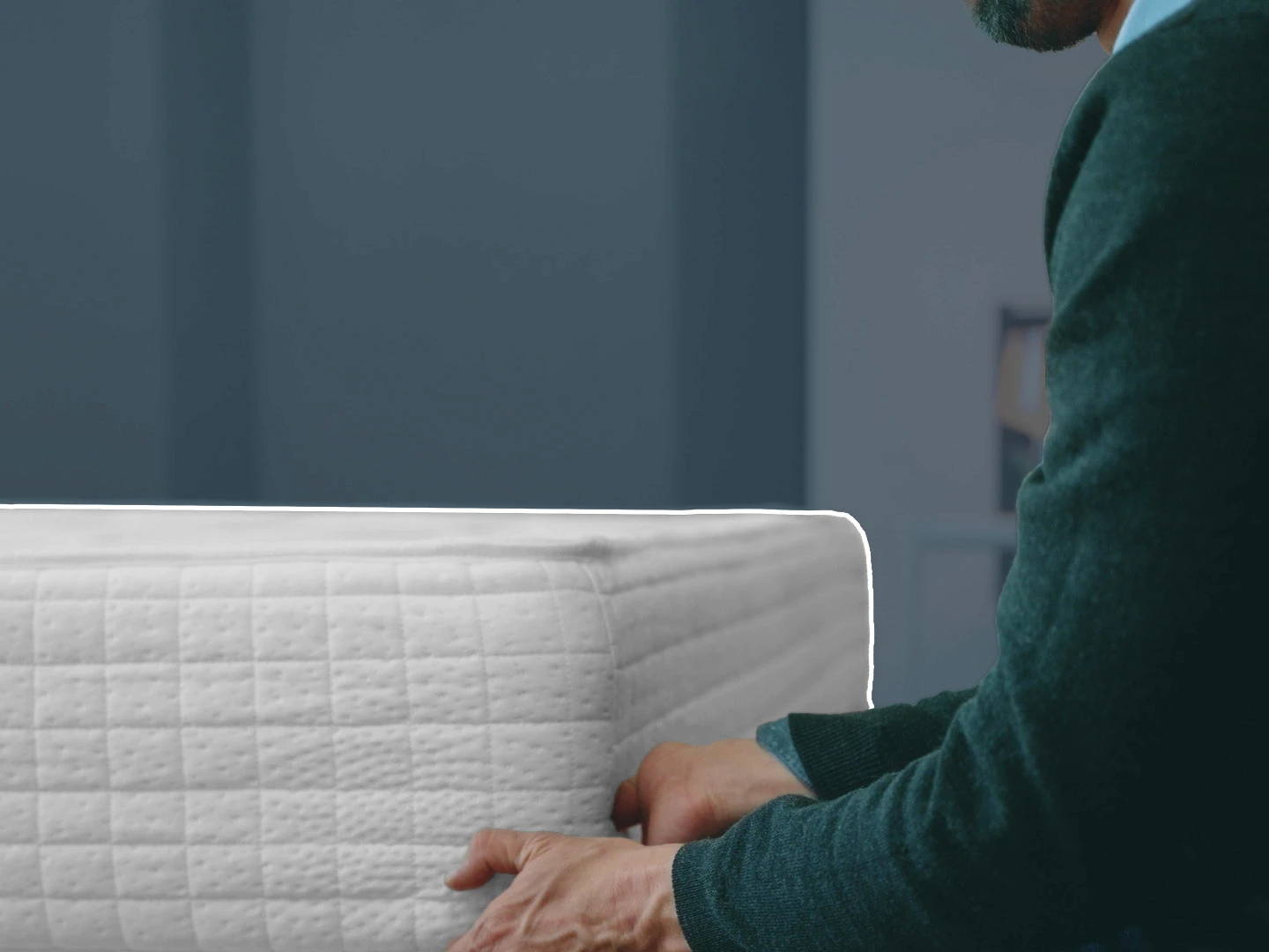 Gros plan d'un homme tenant un matelas par le dessous
