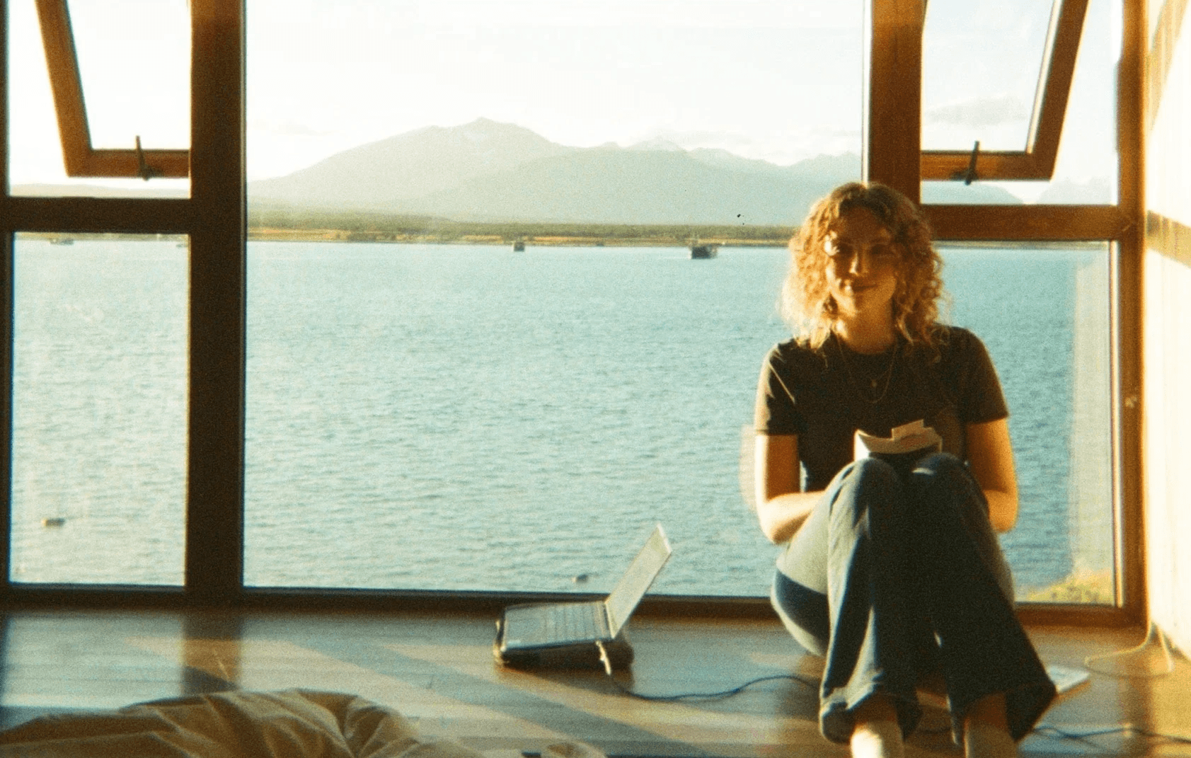 a film photo of a woman standing in front of a window
