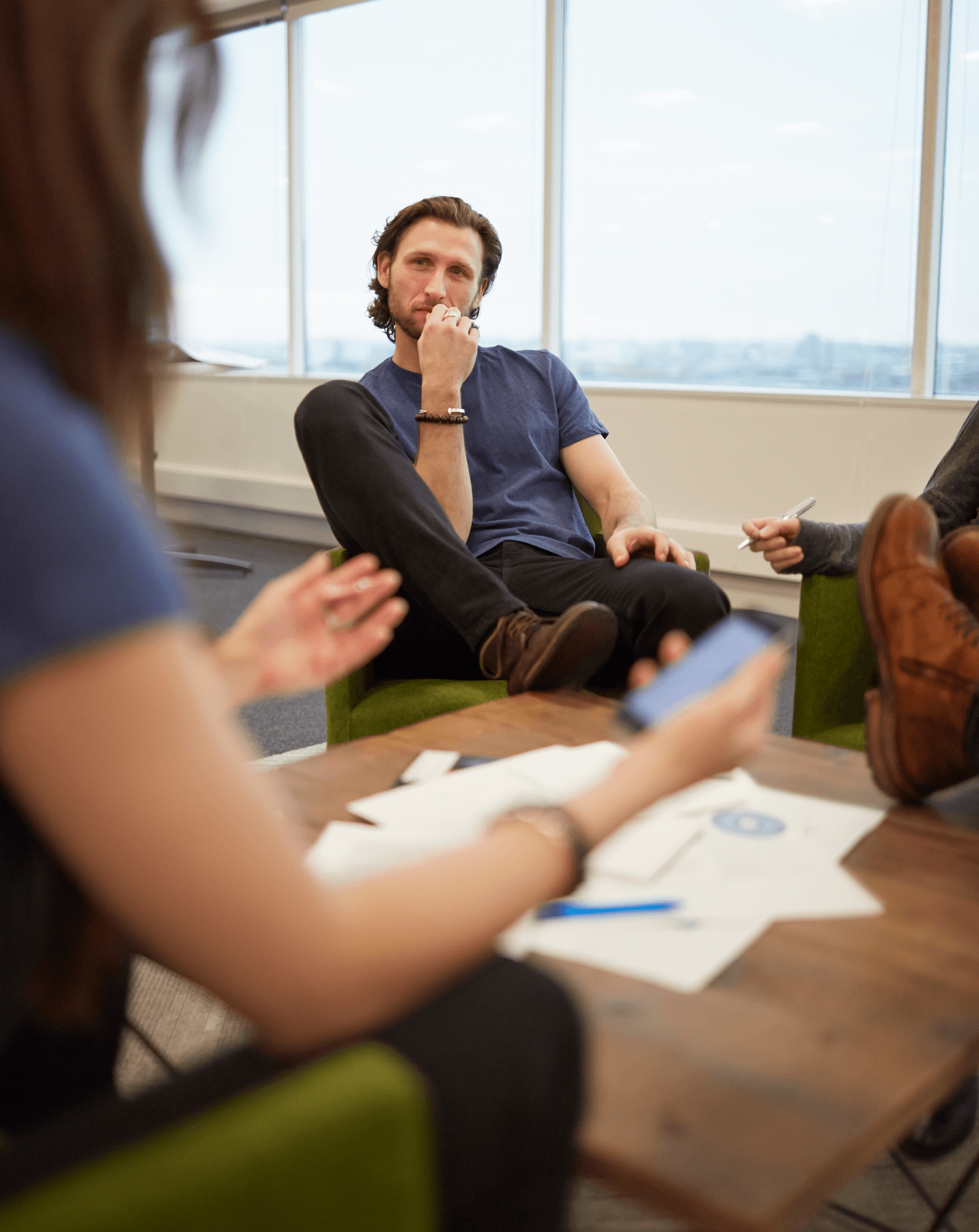 Team having a casual strategy discussion in a bright office space, representing collaboration and problem-solving.