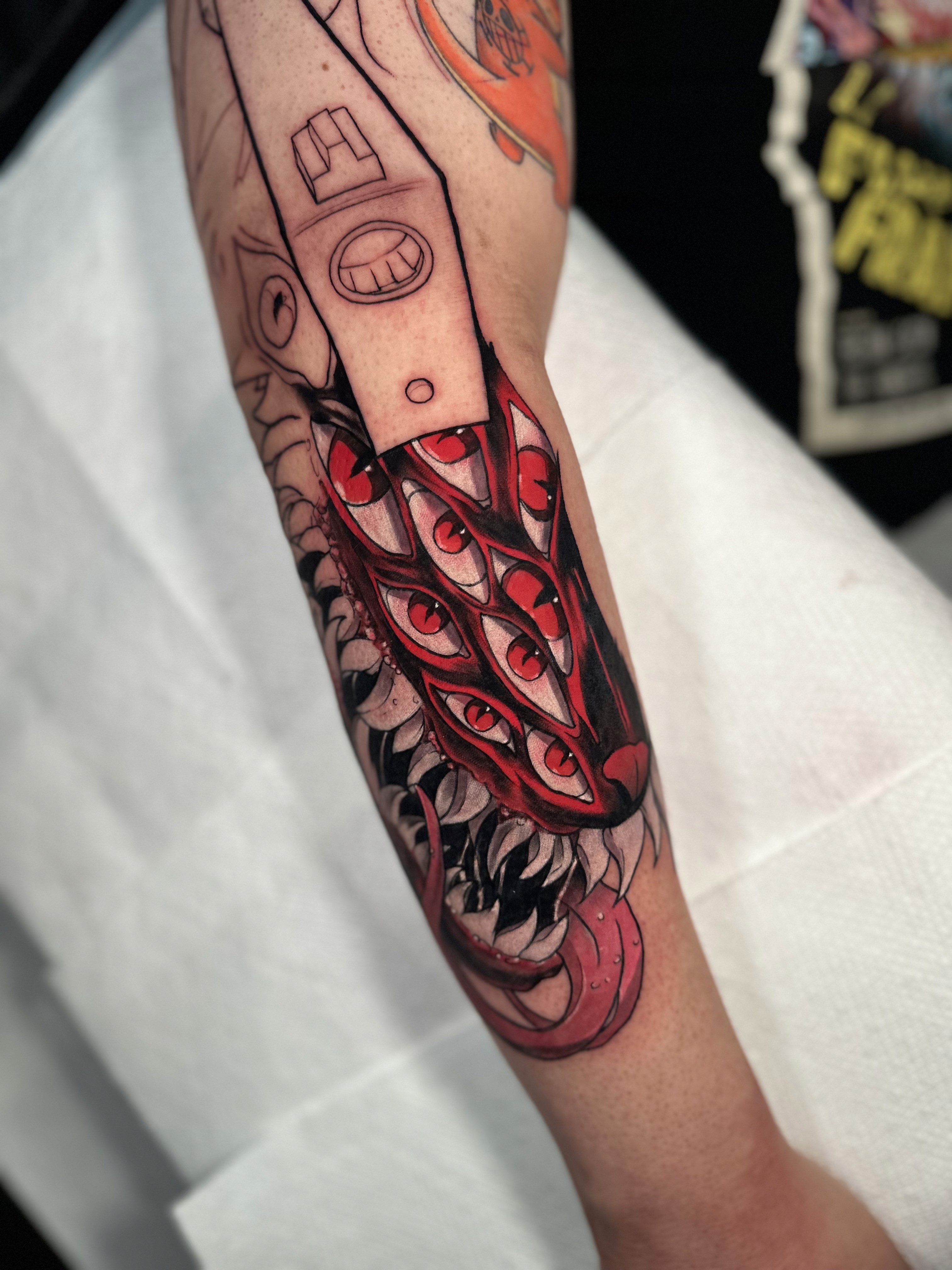 Demonic Eyes & Blade: Surreal Forearm Tattoo