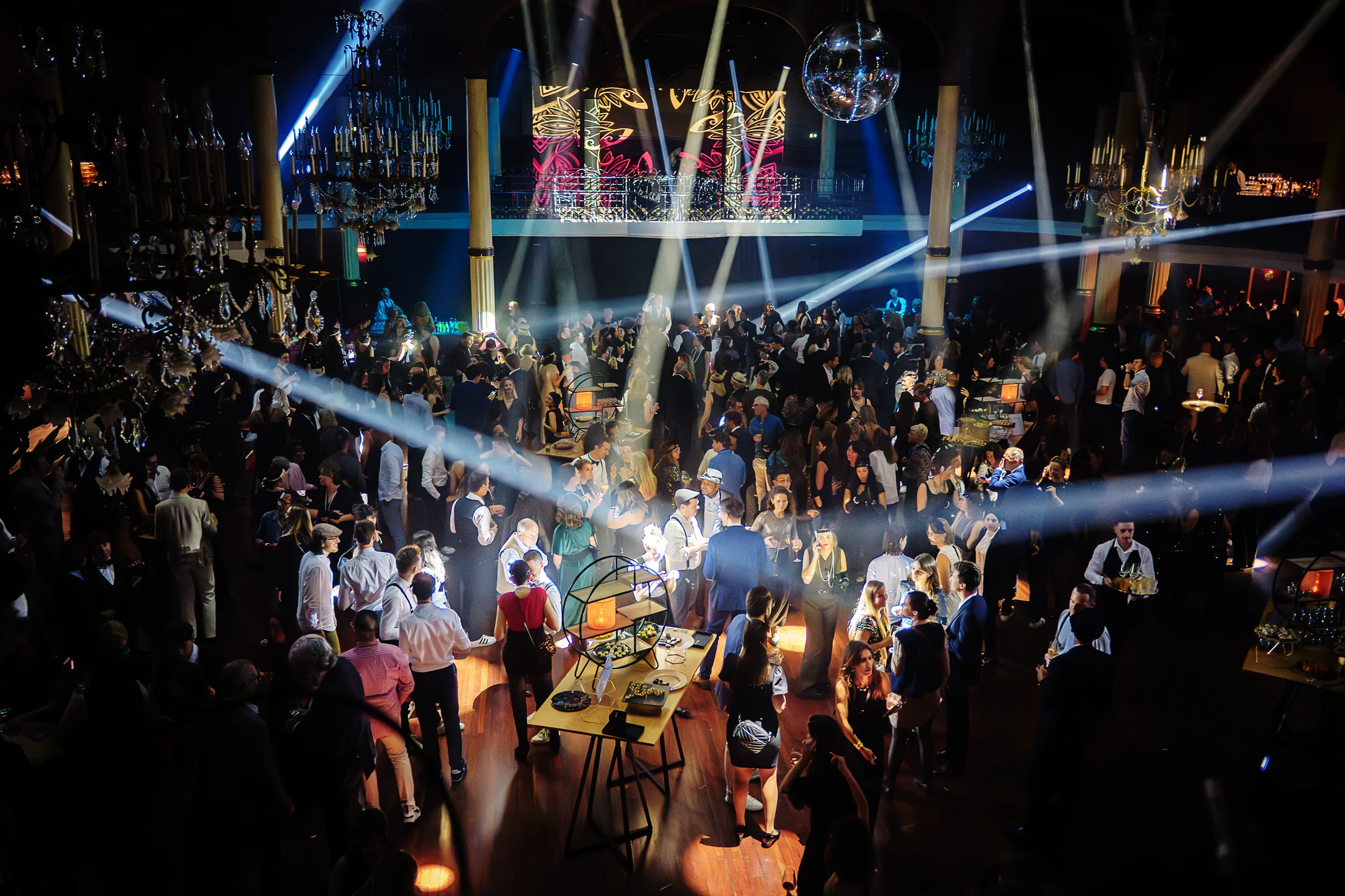 Piste de danse animée lors d’un gala d’entreprise avec éclairages scéniques et forte affluence