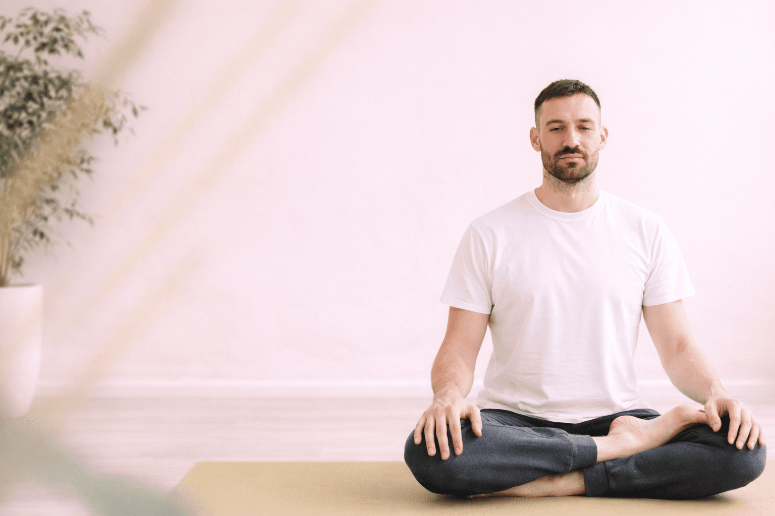 Man meditating in lotus pose on yoga mat