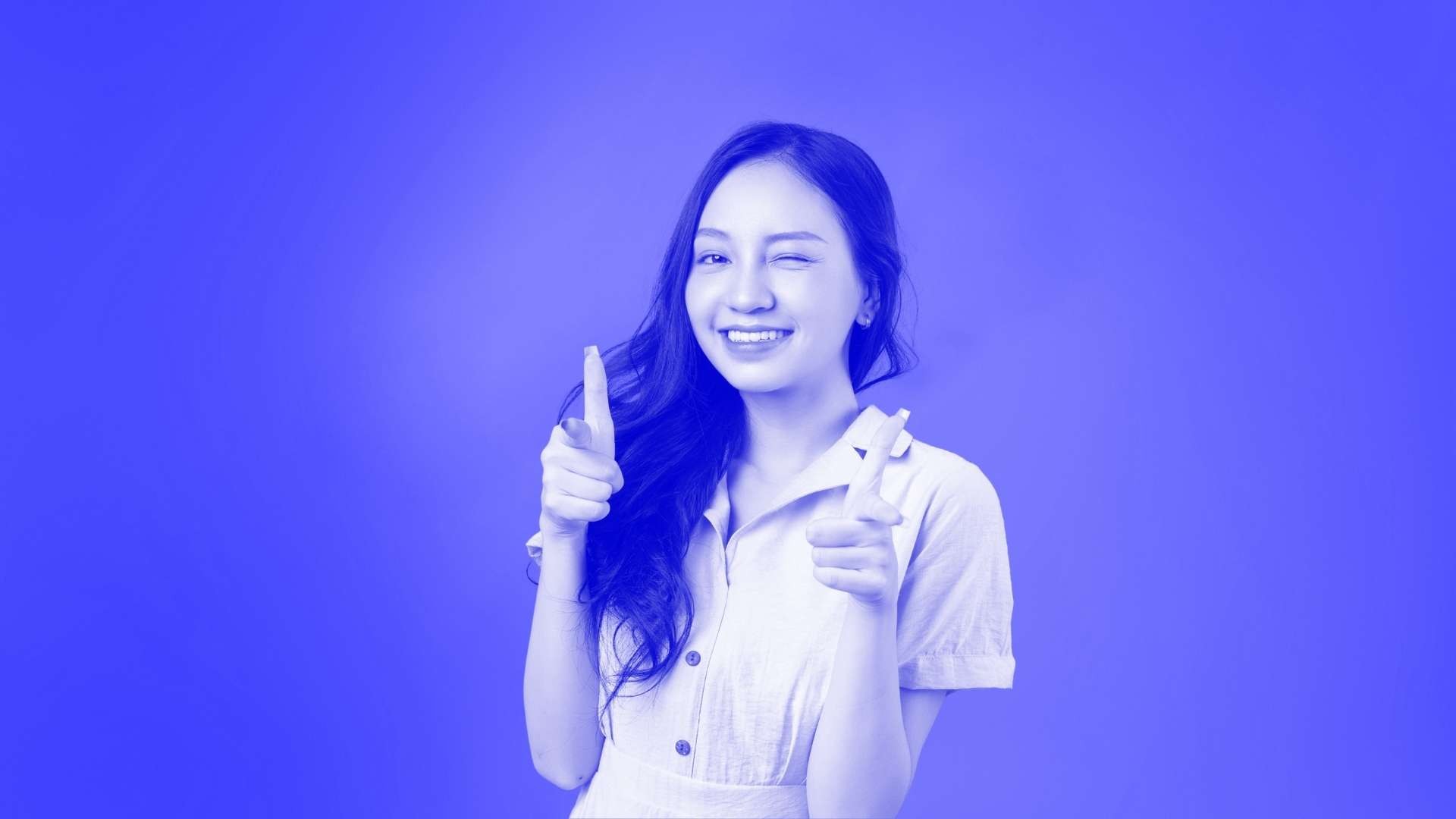 A woman winking and pointing her fingers forward