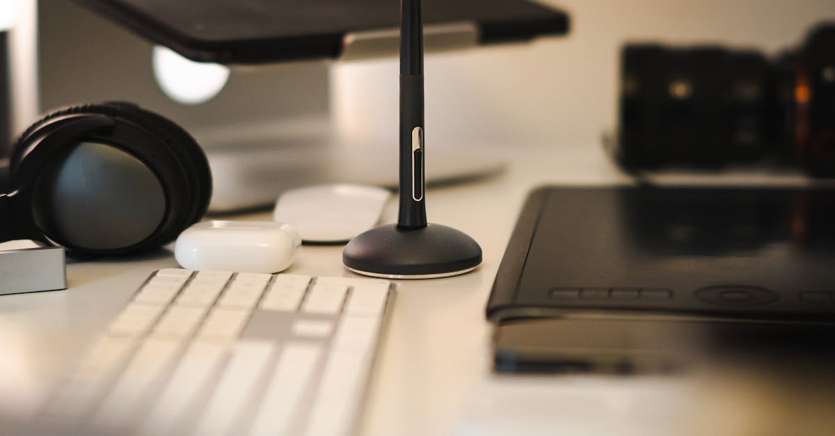 A sleek modern workspace featuring a graphic tablet, stylus, keyboard, headphones, and camera.