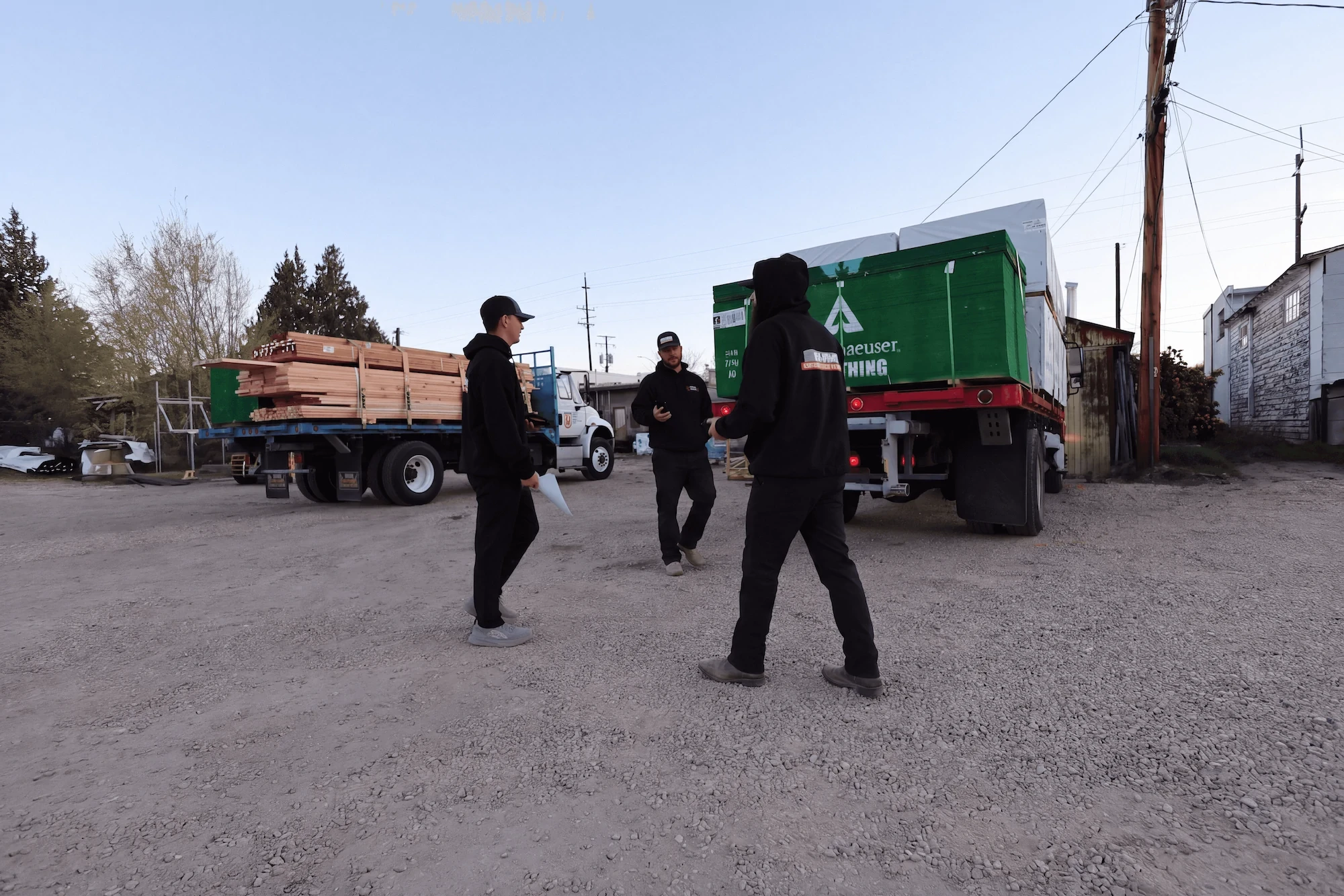 Capital Lumber yard crew meeting beside delivery trucks in Boise