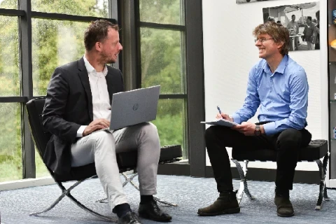 Two Exsion team members discussing work with a laptop