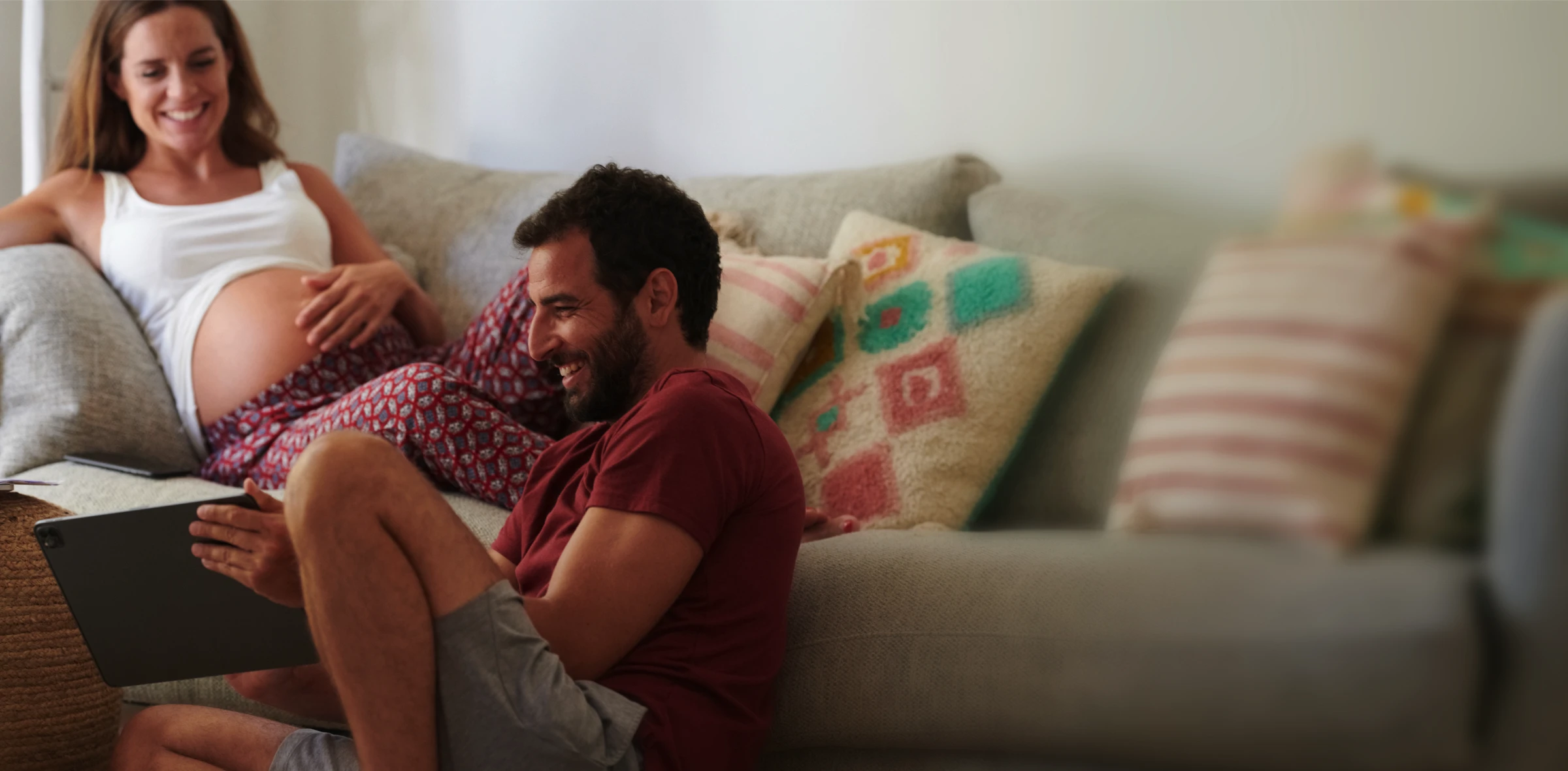 A woman named Jenny O with black hair smiles while sitting on a wooden surface, with shelves in the background.
