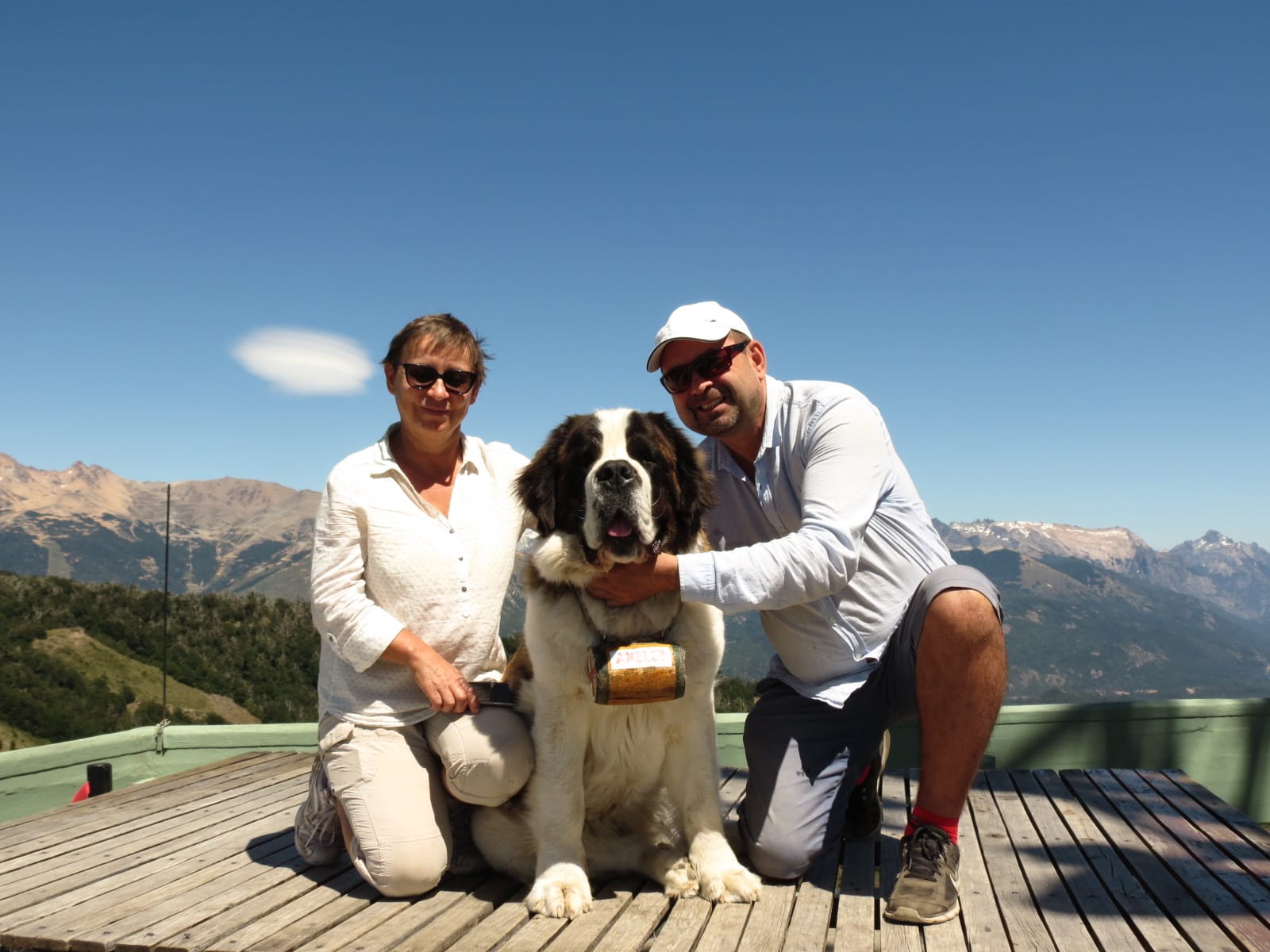 Mujer sentada sobre un tronco frente a una cascada doble en un bosque frondoso de Argentina.