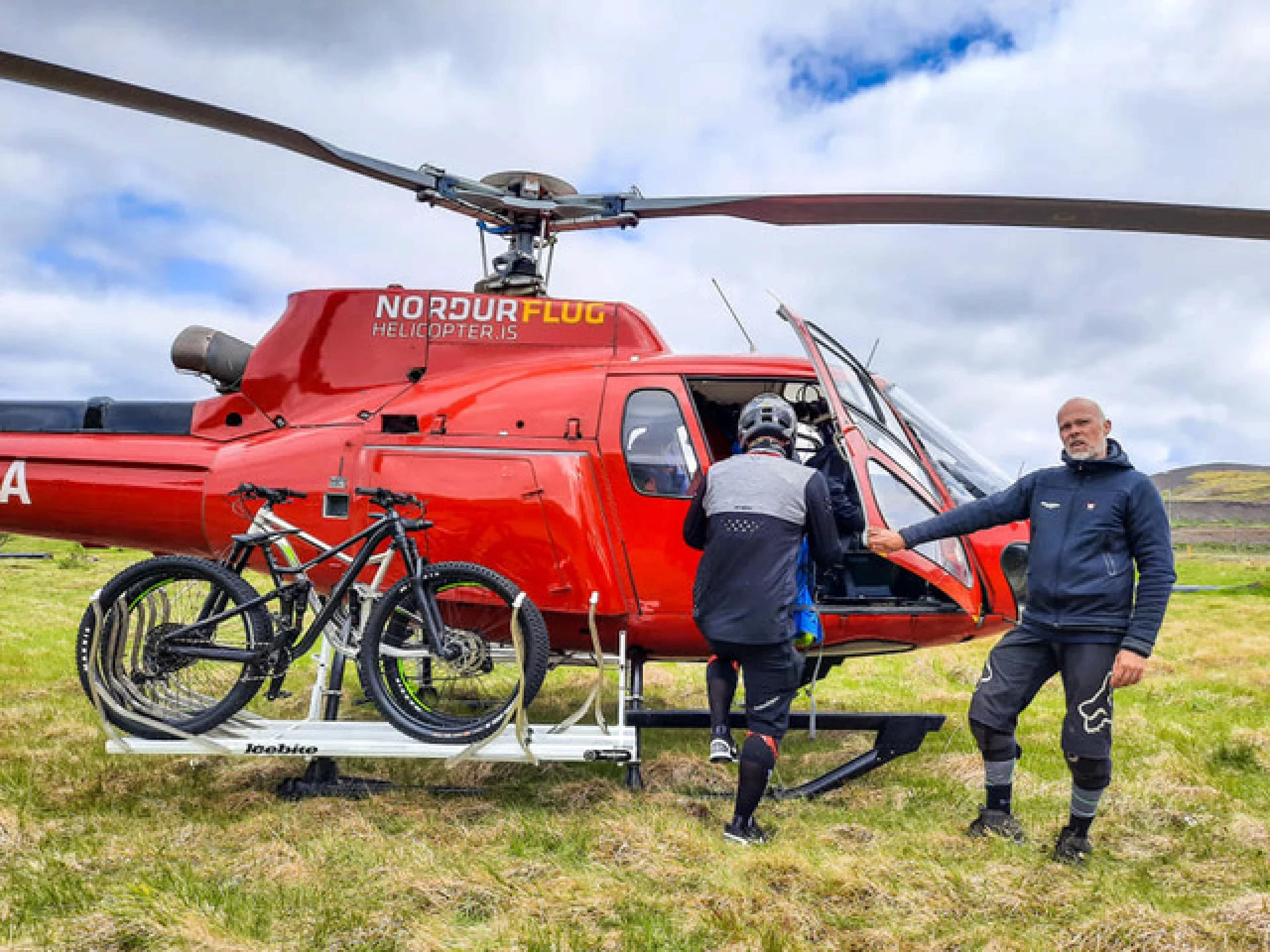 People in front of helicopter with a bike mounted on a biketrailer