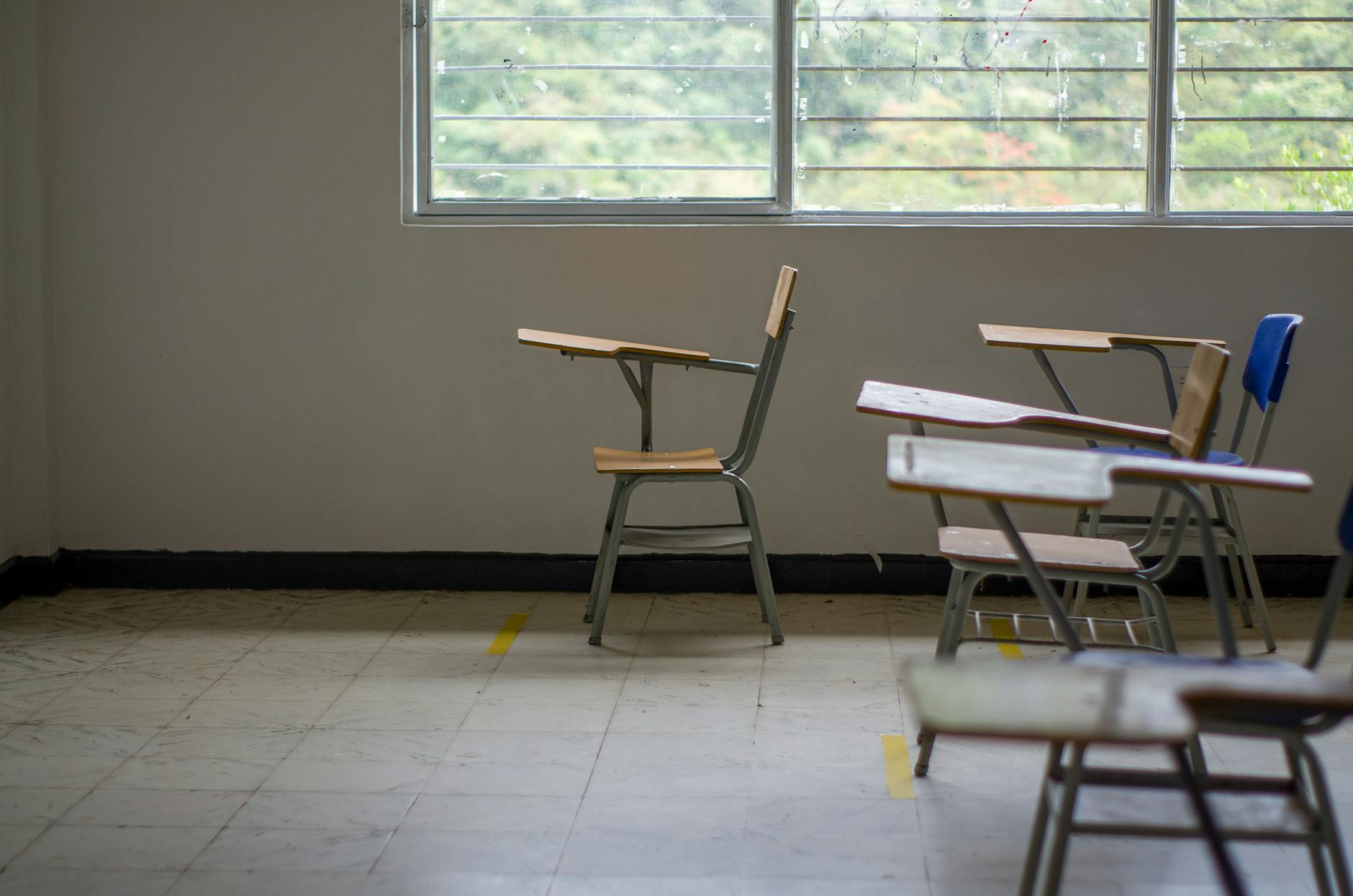 Wide shot of an organized middle school classroom featuring colorful posters, grouped desks, and reading corners.