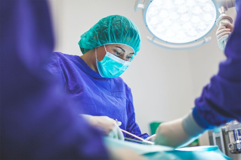 Surgeon performing an operation in a hospital operating room.